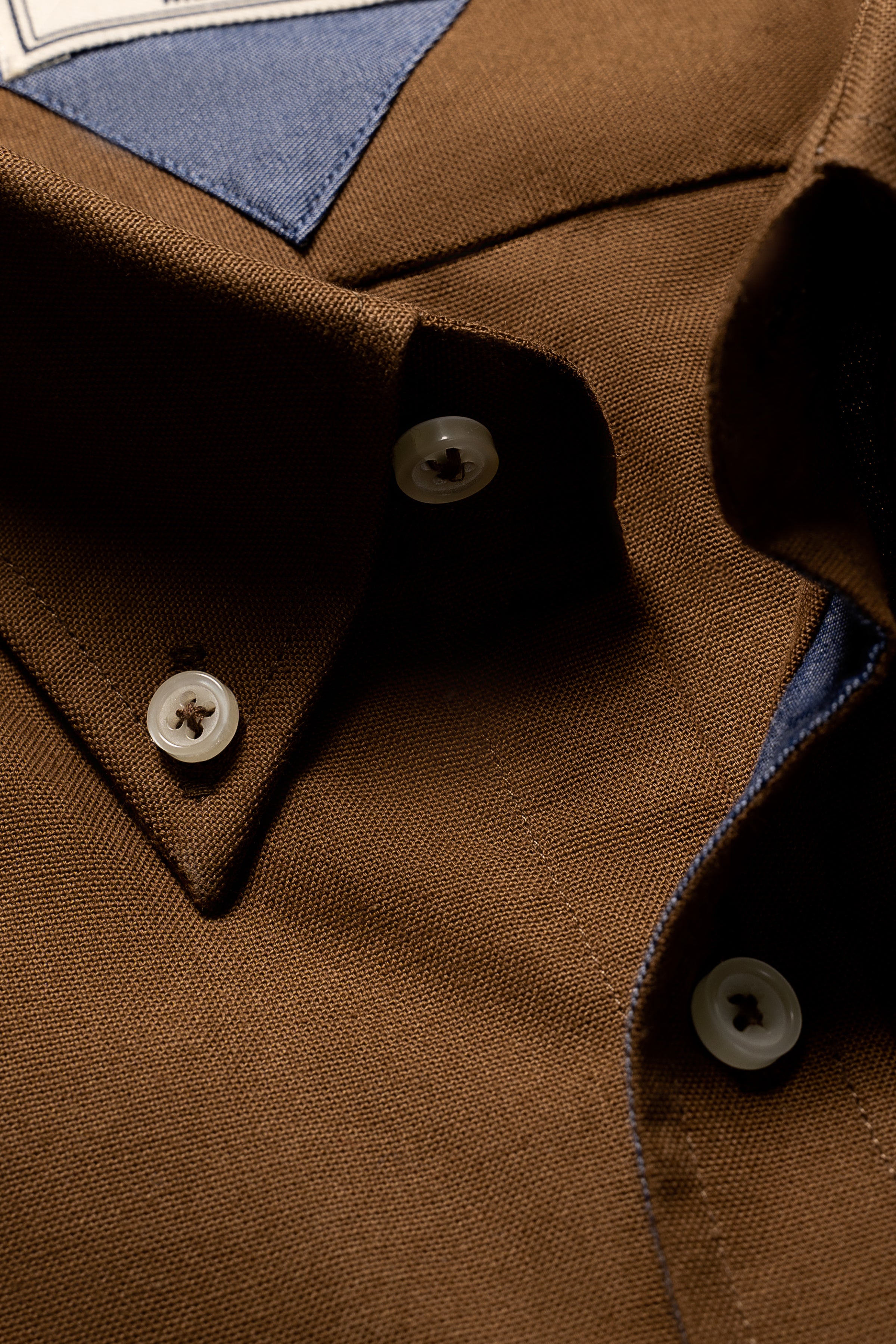 Brown dress shirt collar and button placket with blue inner lining