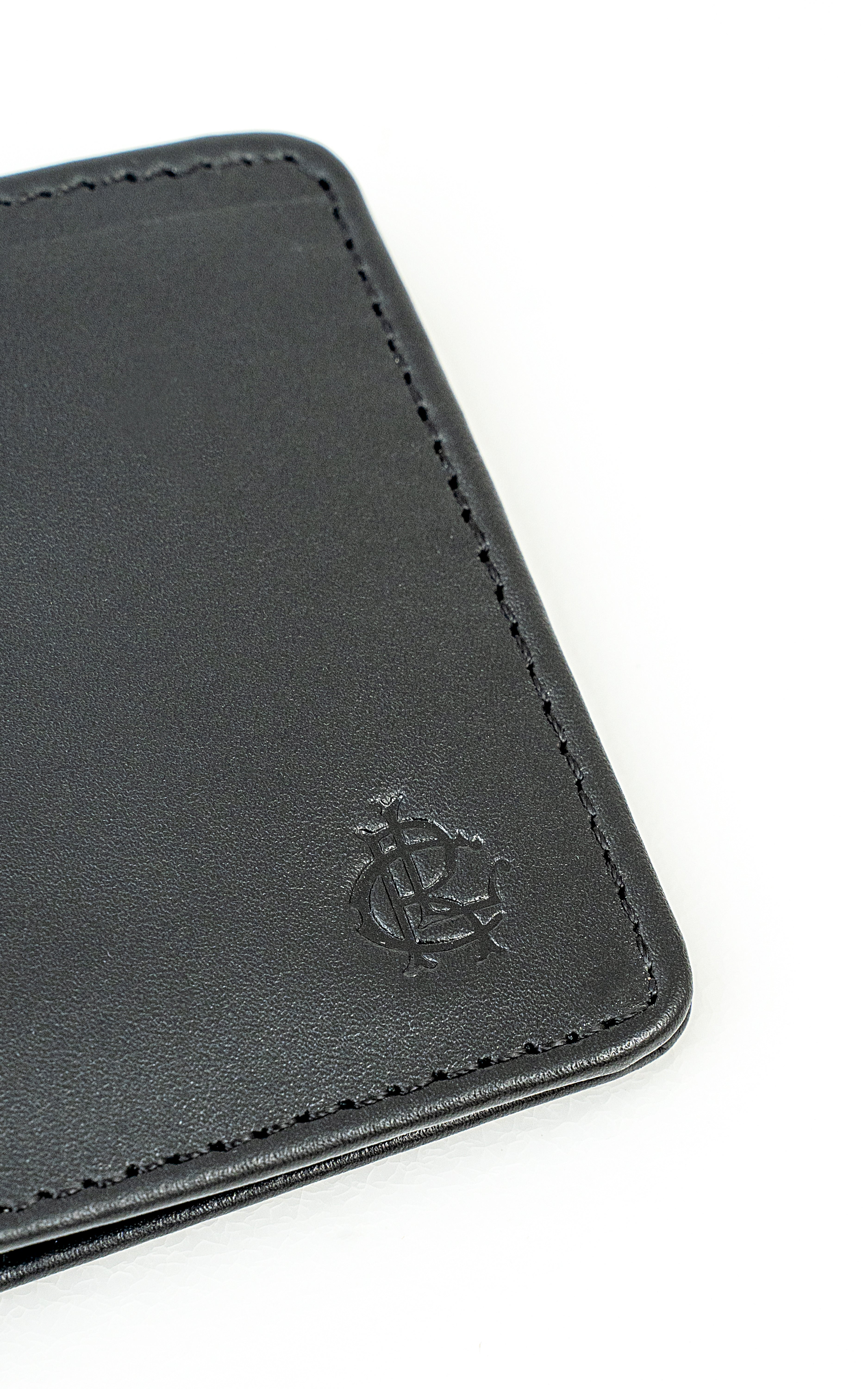 Black leather wallet close-up of embossed logo and contrast stitching.
