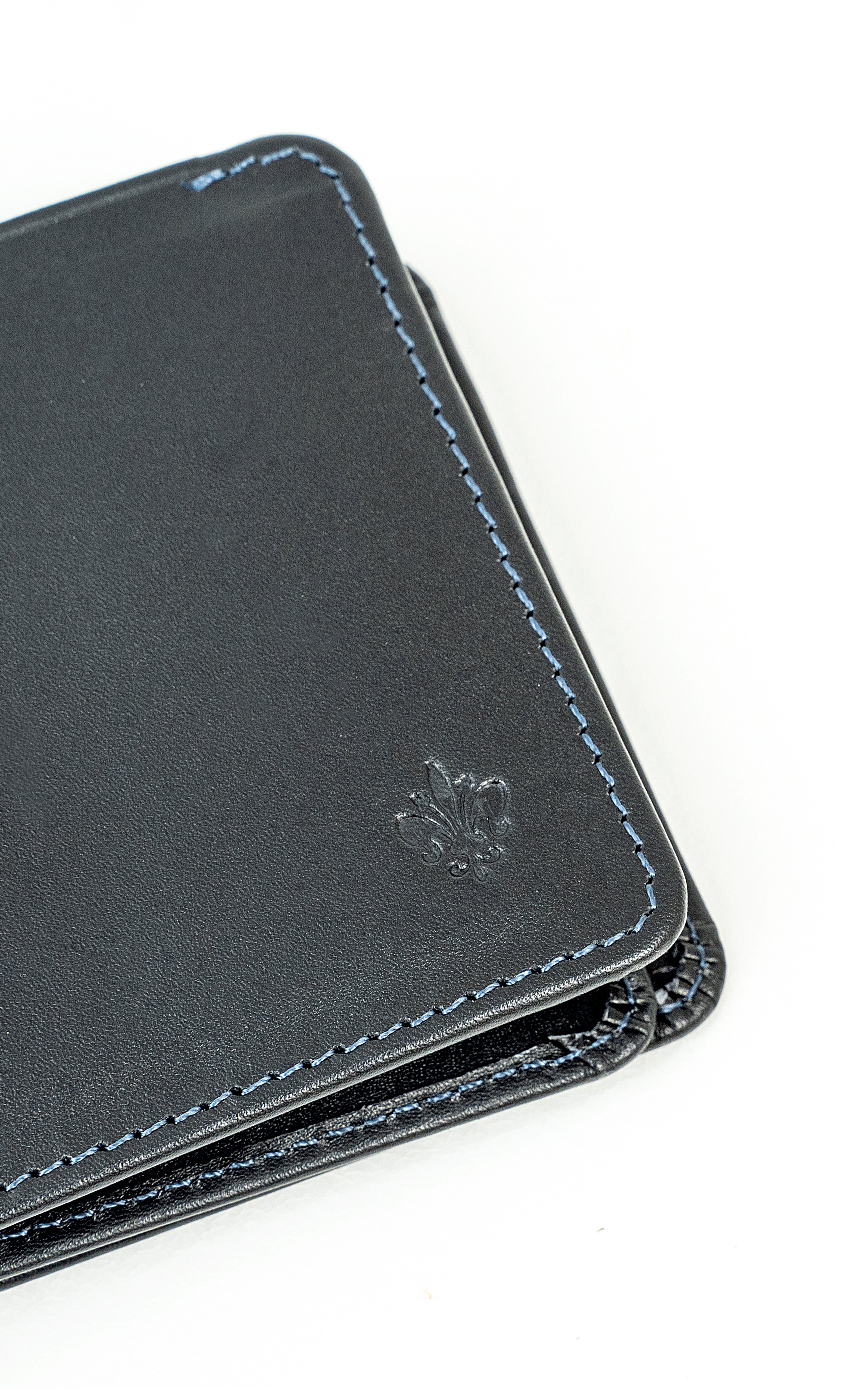Leather wallet corner close-up with blue stitching and embossed logo.