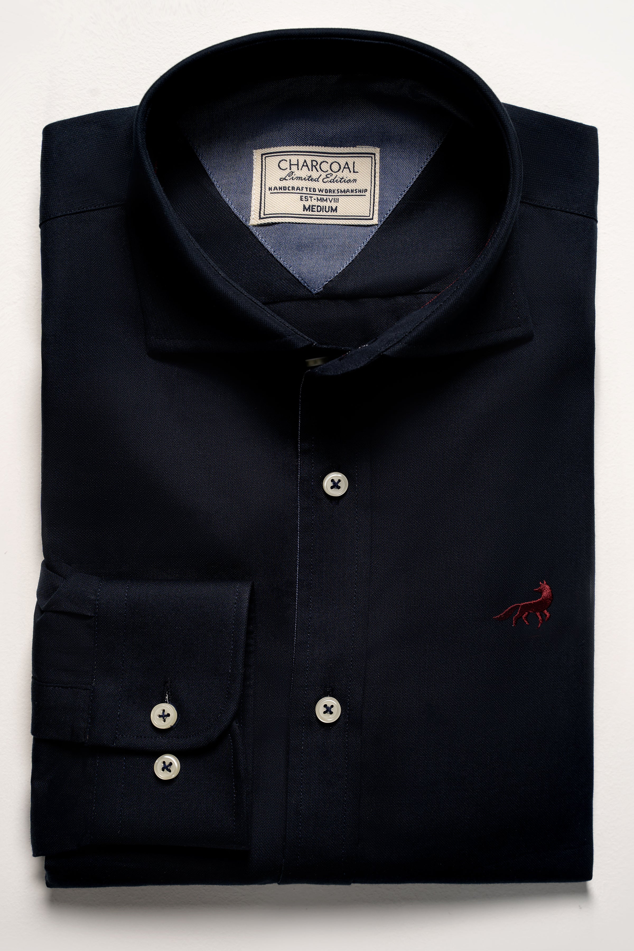 Navy dress shirt with button placket, spread collar, and chest logo