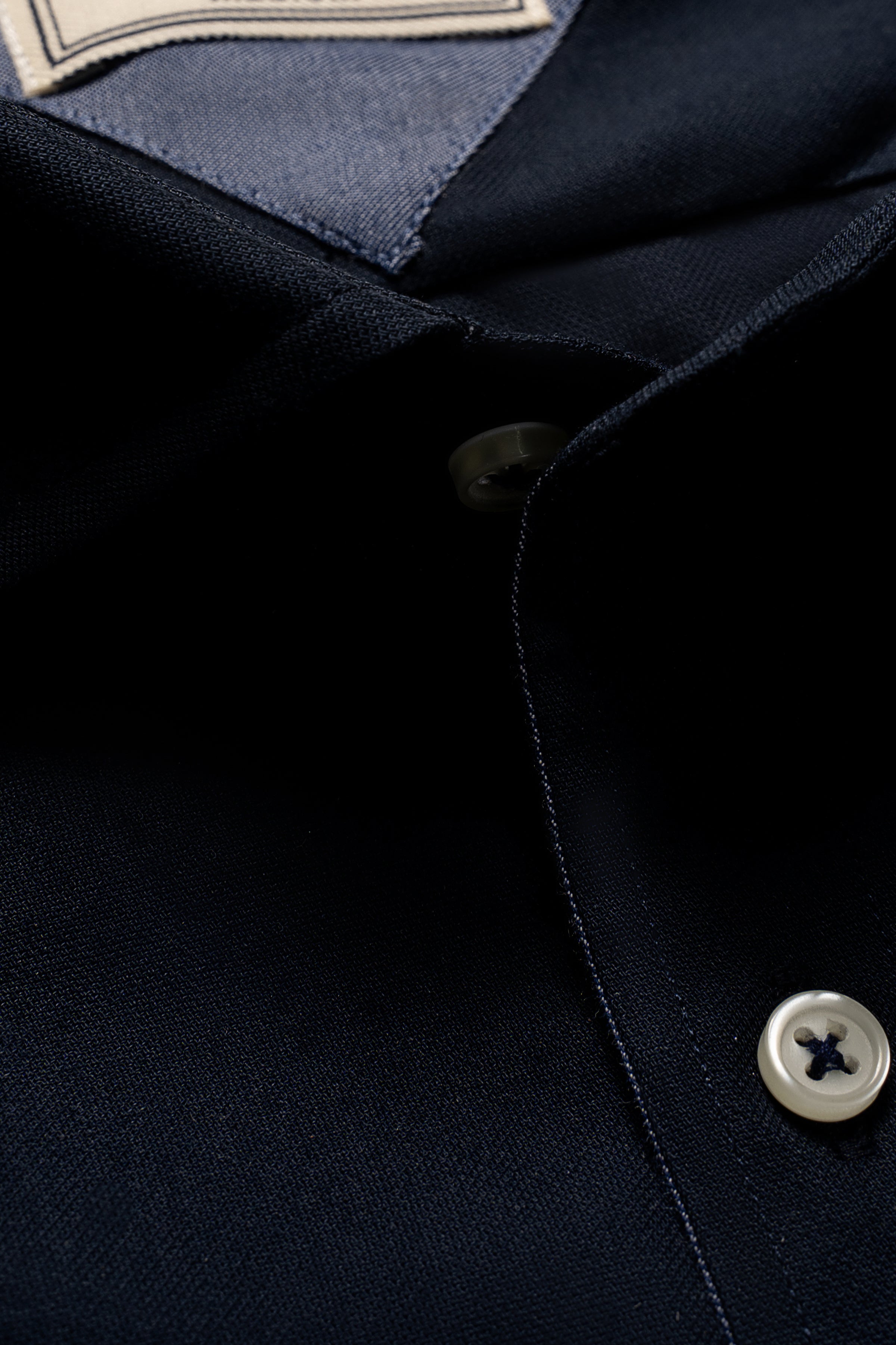 Navy dress shirt close-up of collar seam and white button