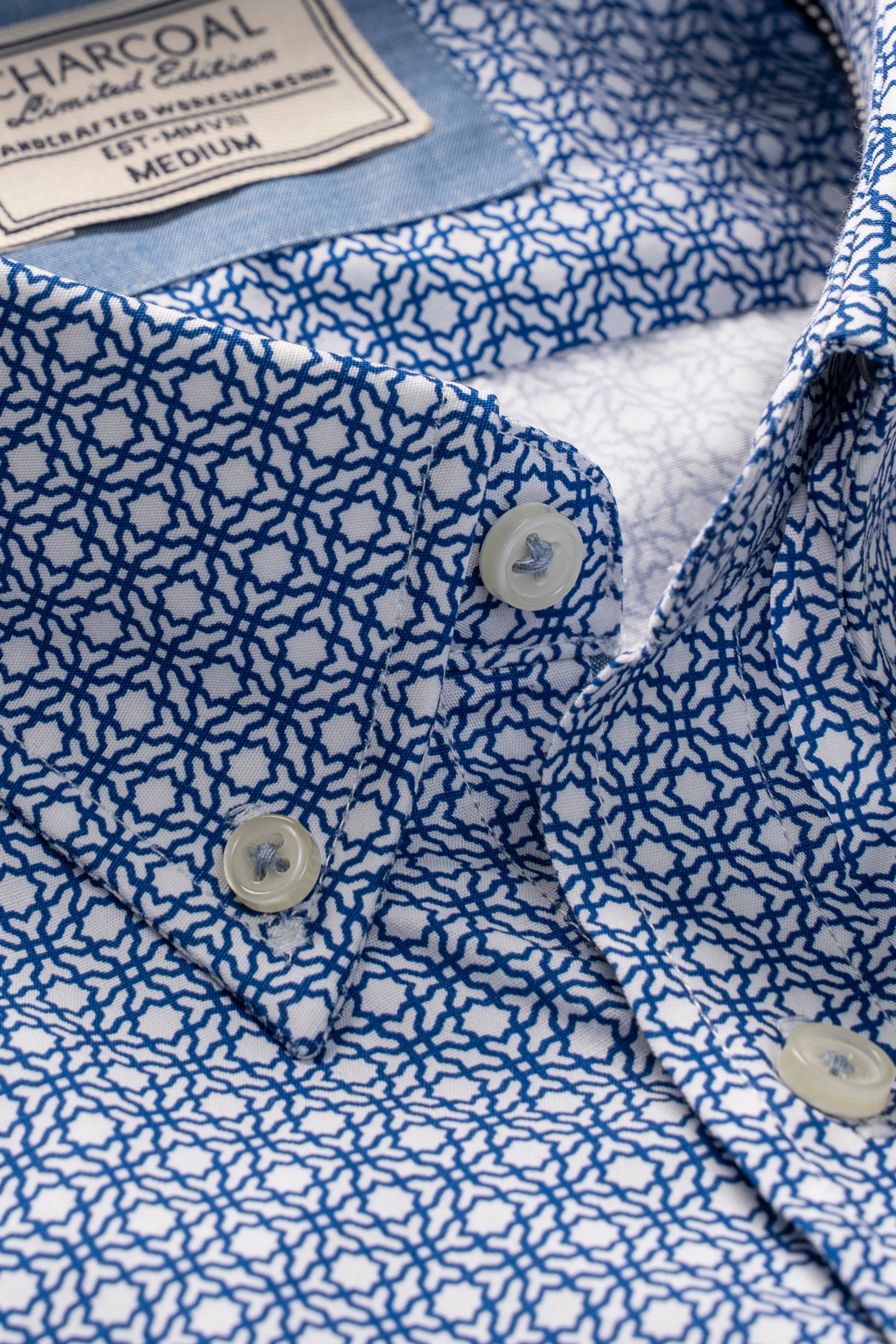 Half-sleeve shirt close-up: navy with white geometric print, button placket and collar