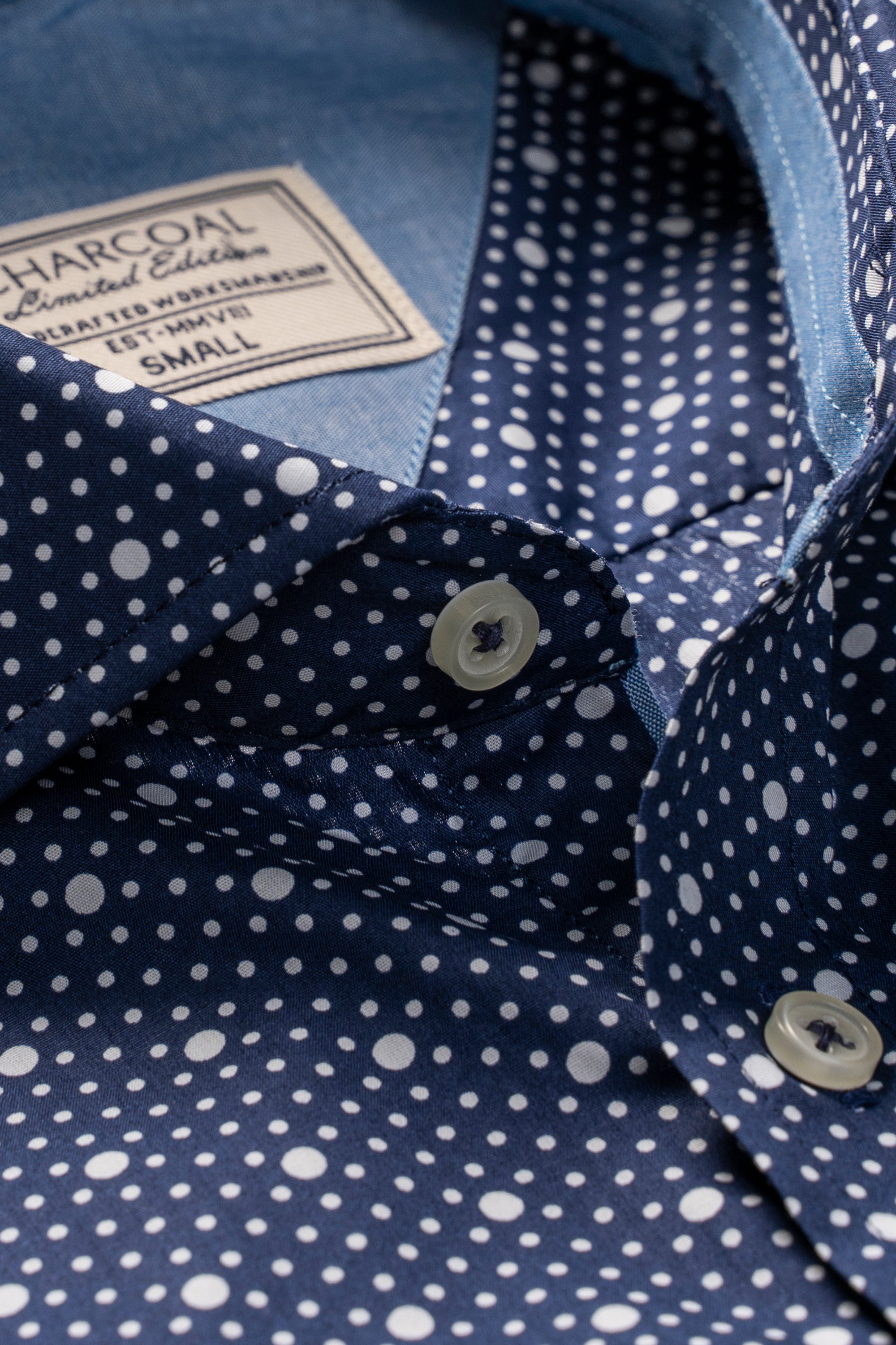 Navy polka-dot shirt collar with white buttons and brand label