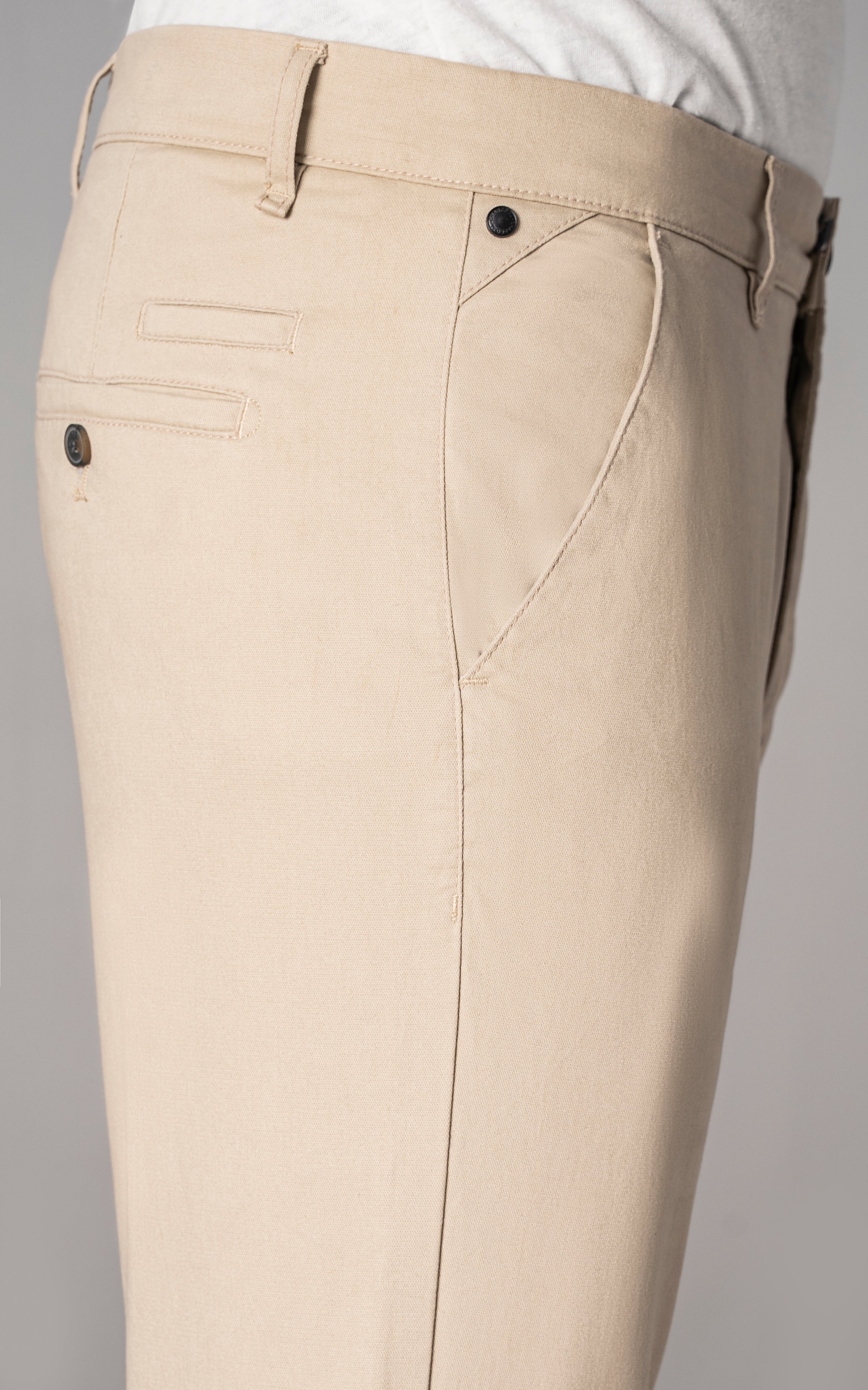 Light khaki trousers close-up: cross pocket, belt loops, button closure, stitched front