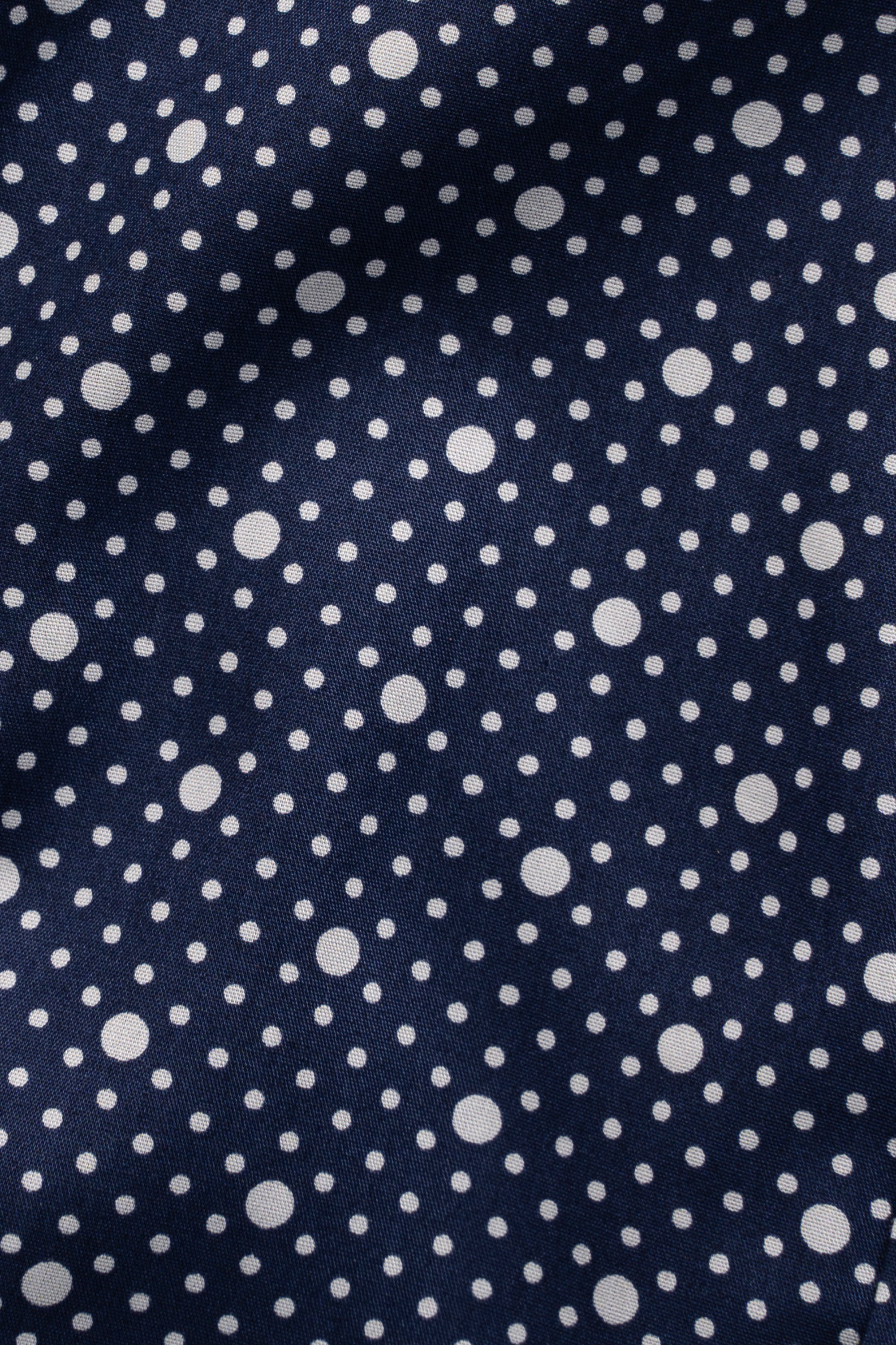 Navy polka-dot shirt fabric texture with scattered white circles
