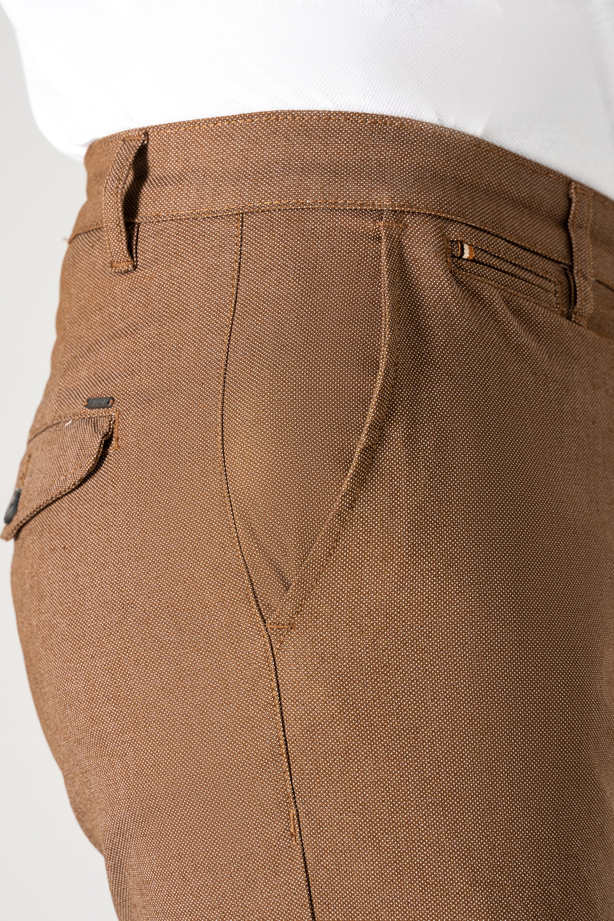 Brown textured cross pocket pants close-up with button and flap