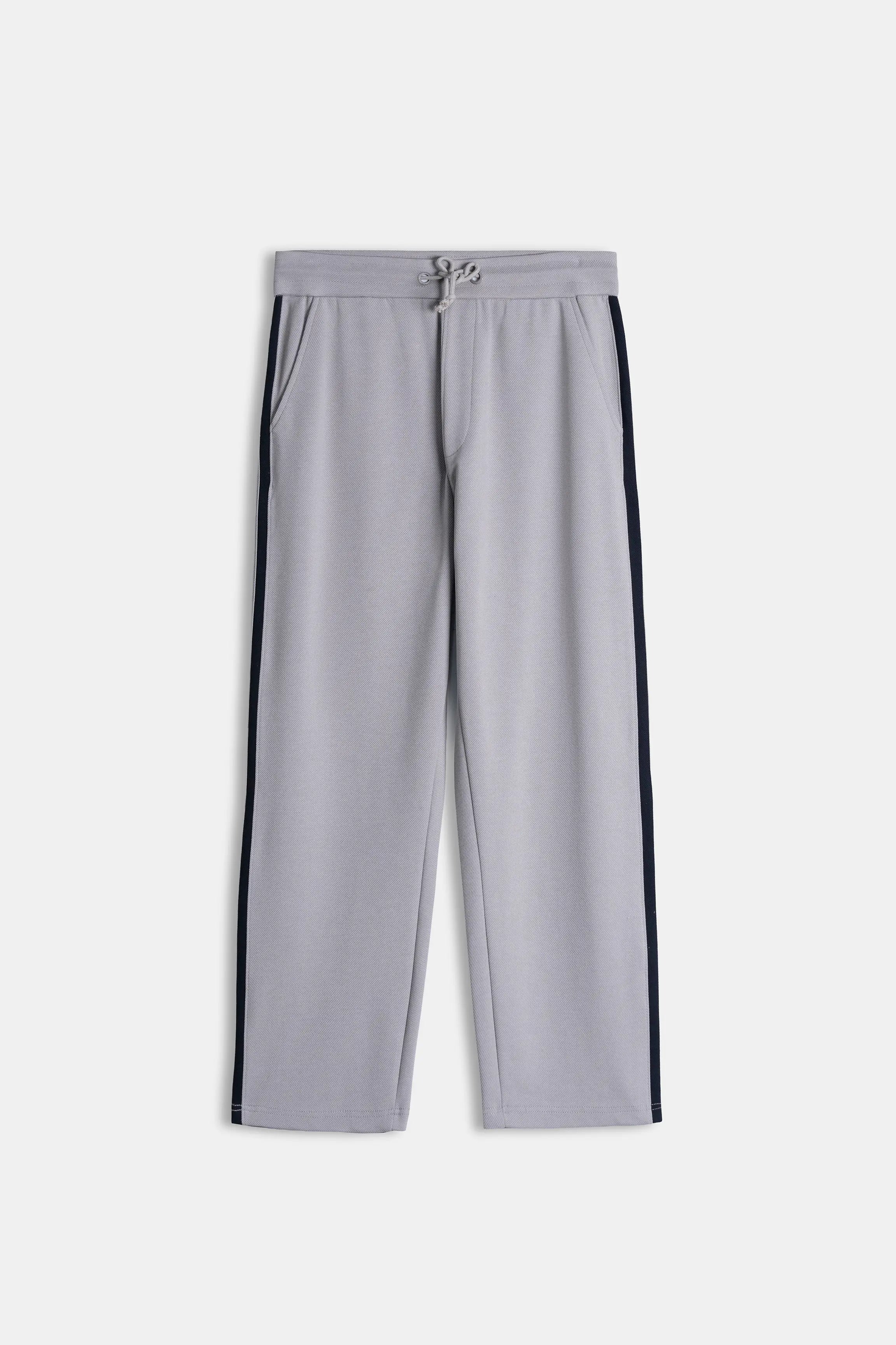 Grey loose trousers with elastic waistband, drawstring, and navy side stripe