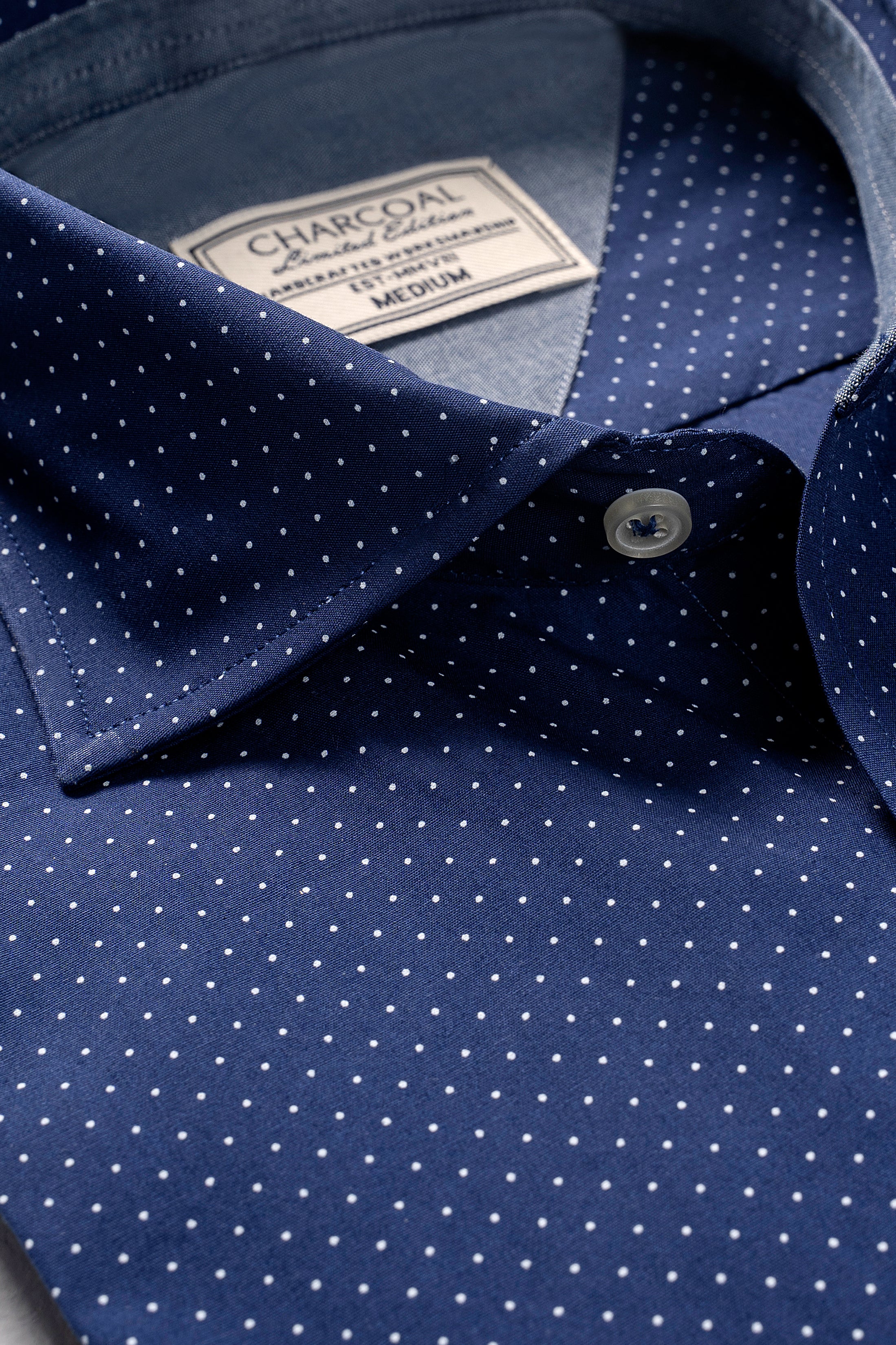 Navy blue dress shirt with white dots, button placket and pointed collar