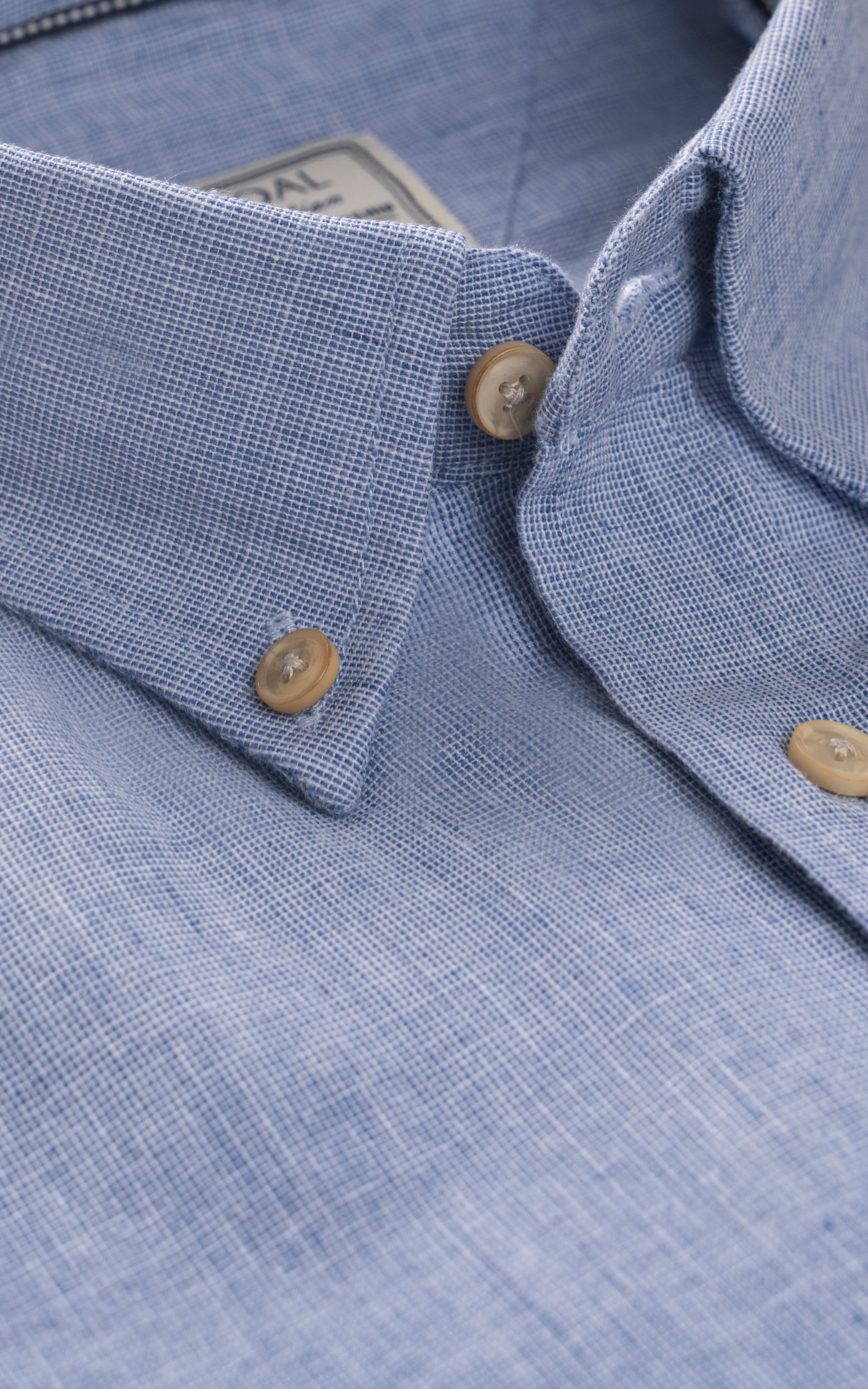 Linen chambray blue shirt collar close-up with button detail