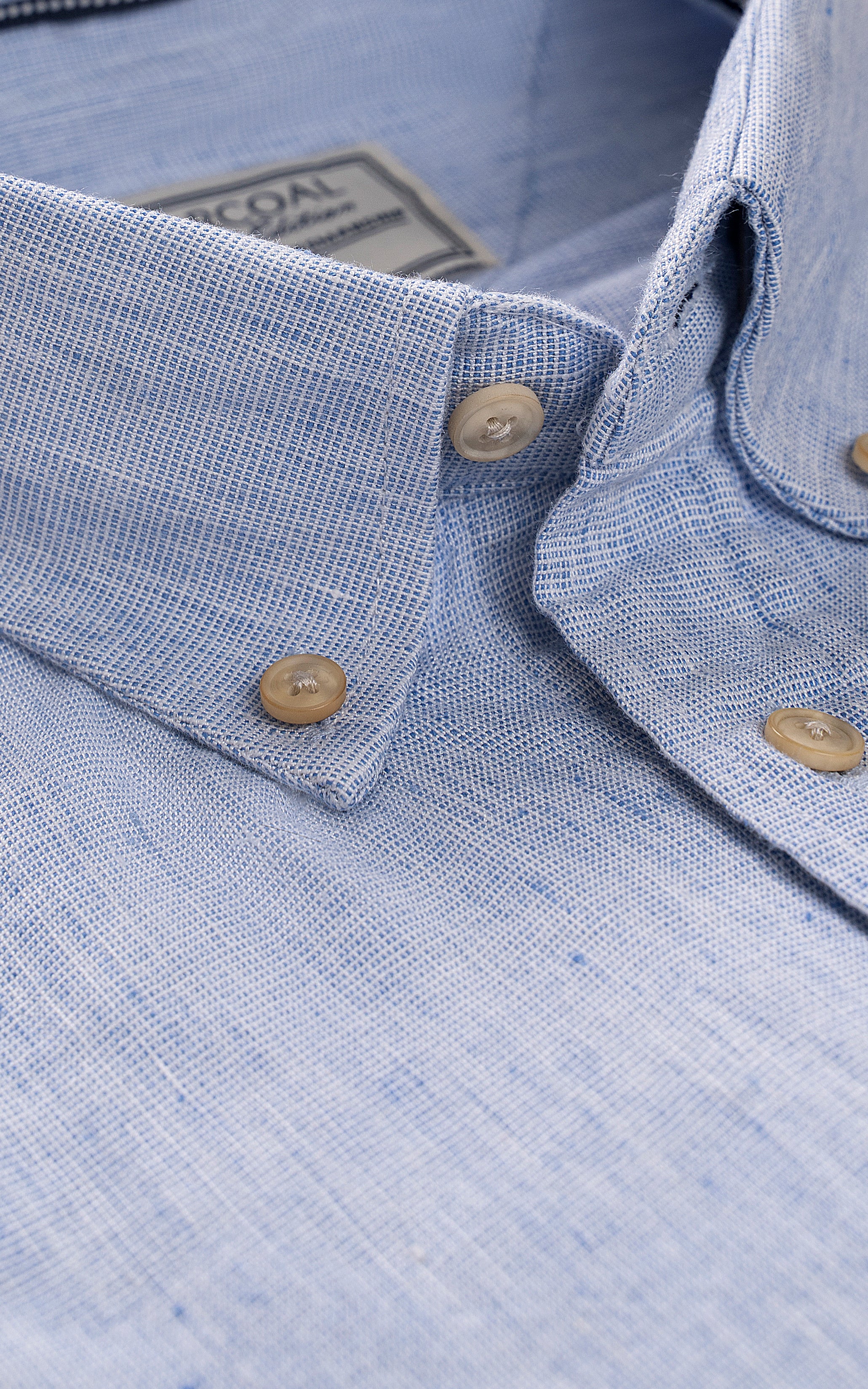 Sky blue linen shirt close-up, textured weave, button cuffs and placket