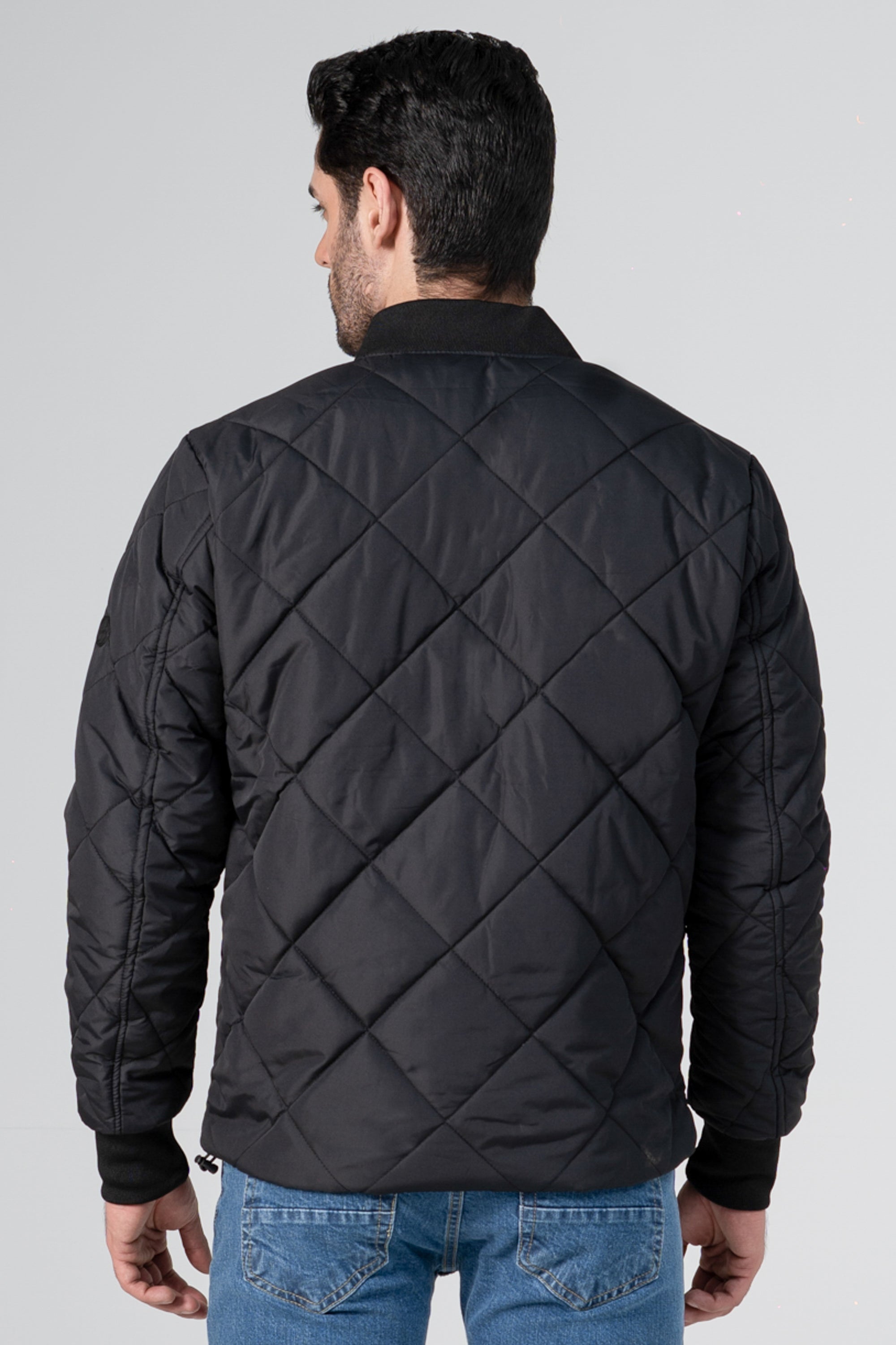 Quilted black bomber jacket back view with diamond pattern and ribbed cuffs
