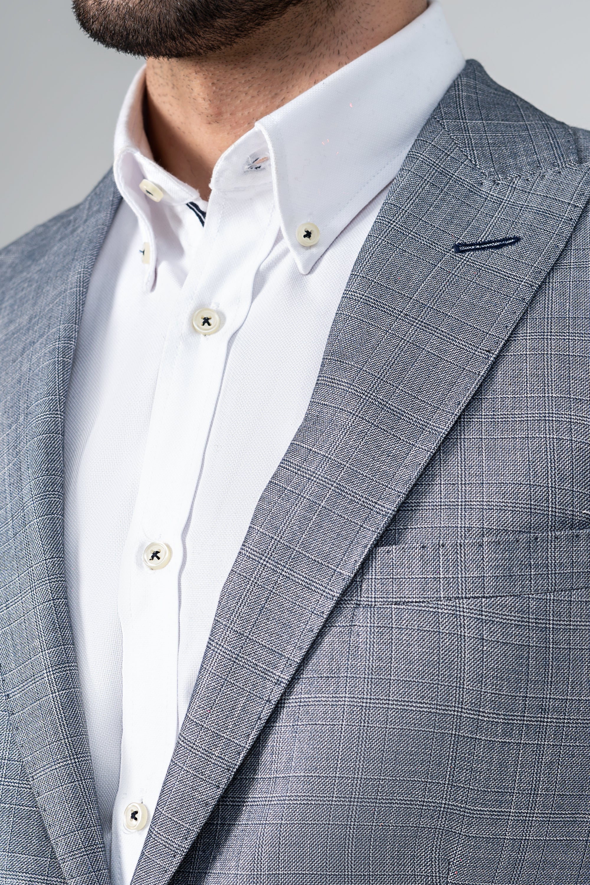 Casual coat blazer close-up: light gray textured fabric, notch lapel, chest pocket.