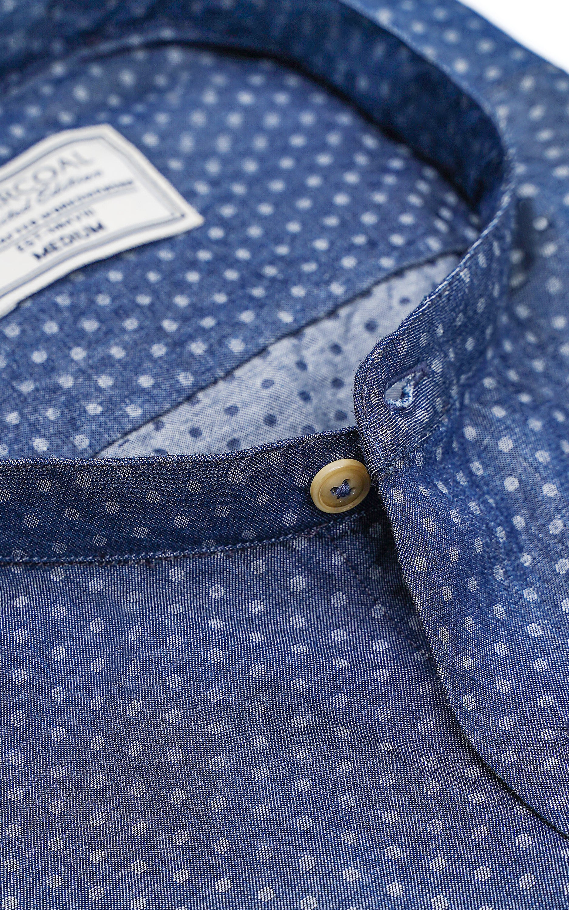 Blue dress shirt collar with dotted pattern and gold button