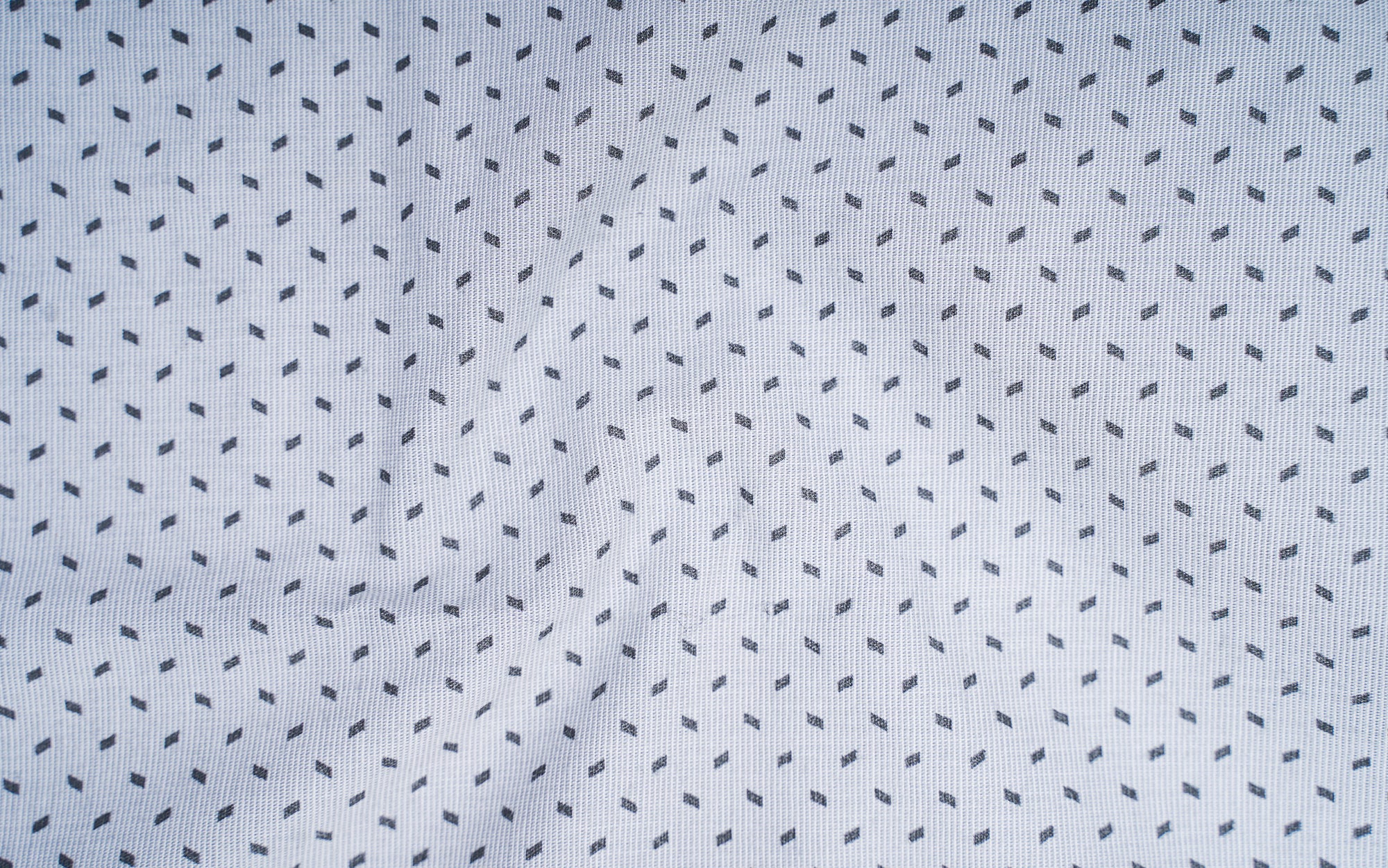 Light grey shirt fabric with small black geometric pattern of dotted angular marks