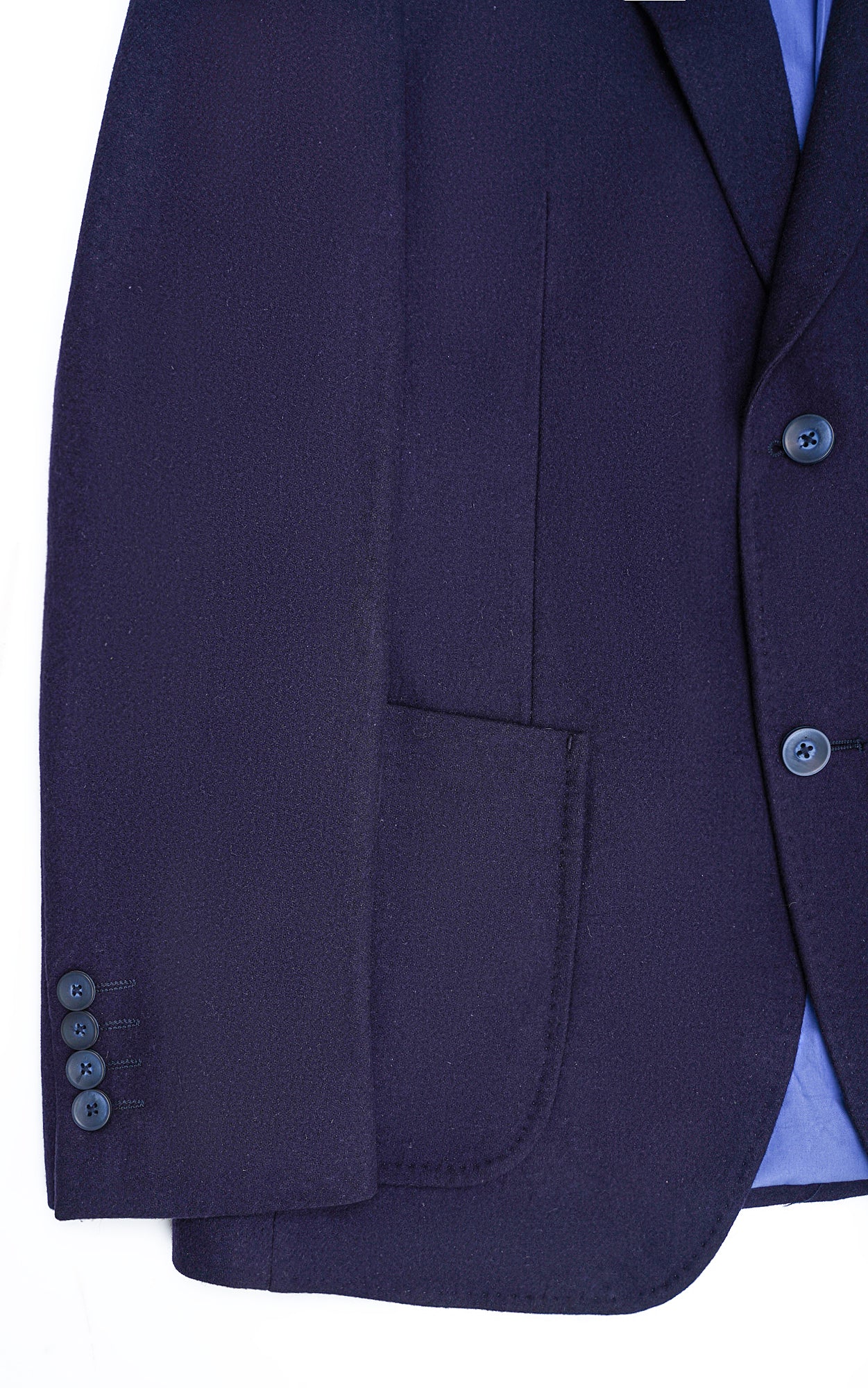 Navy woolen coat front detail with flap pockets and dark buttons