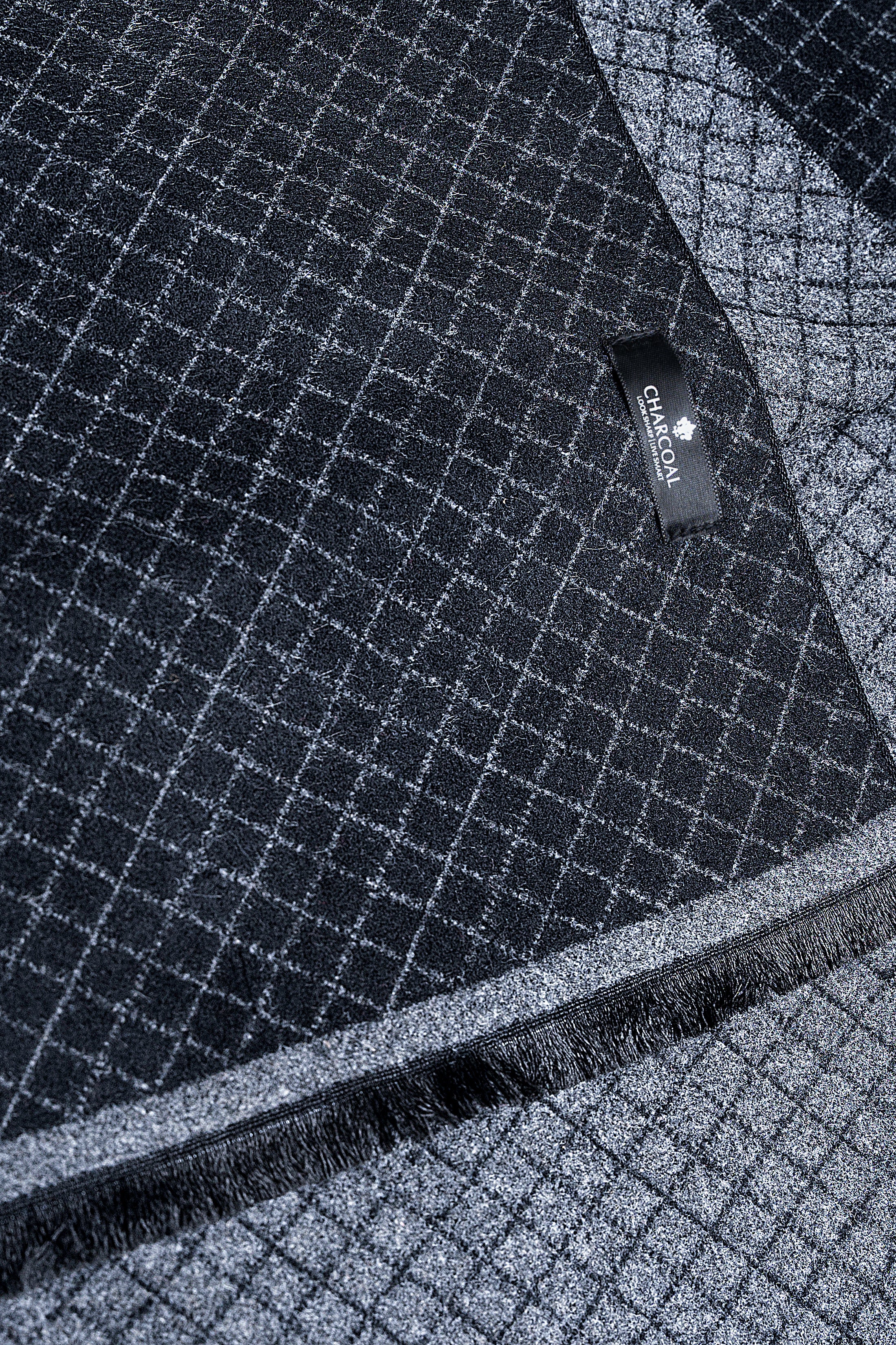 Close-up of dark navy grid scarf with brand label and fringed trim