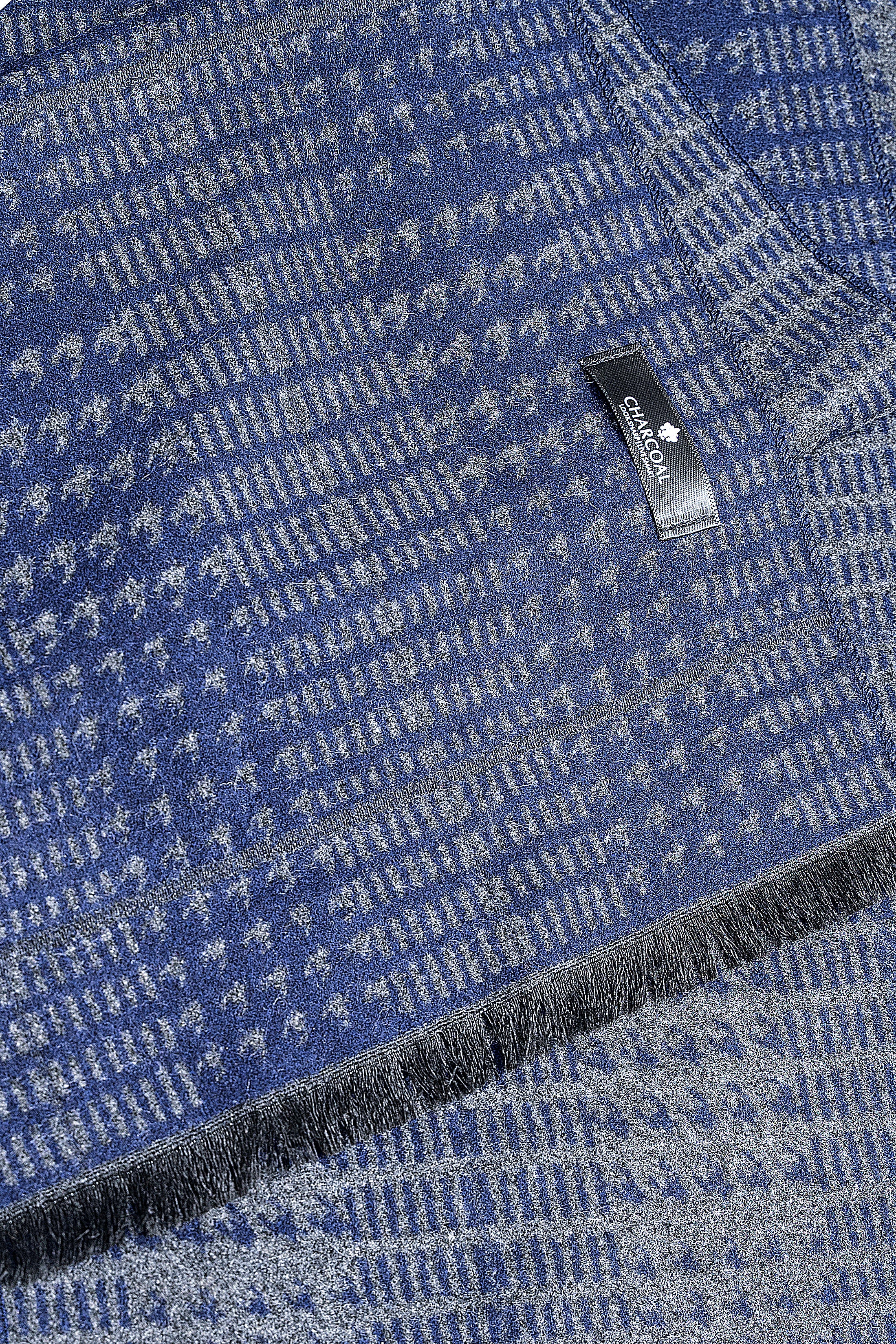 Blue patterned scarf detail with woven texture, logo patch, and fringed trim