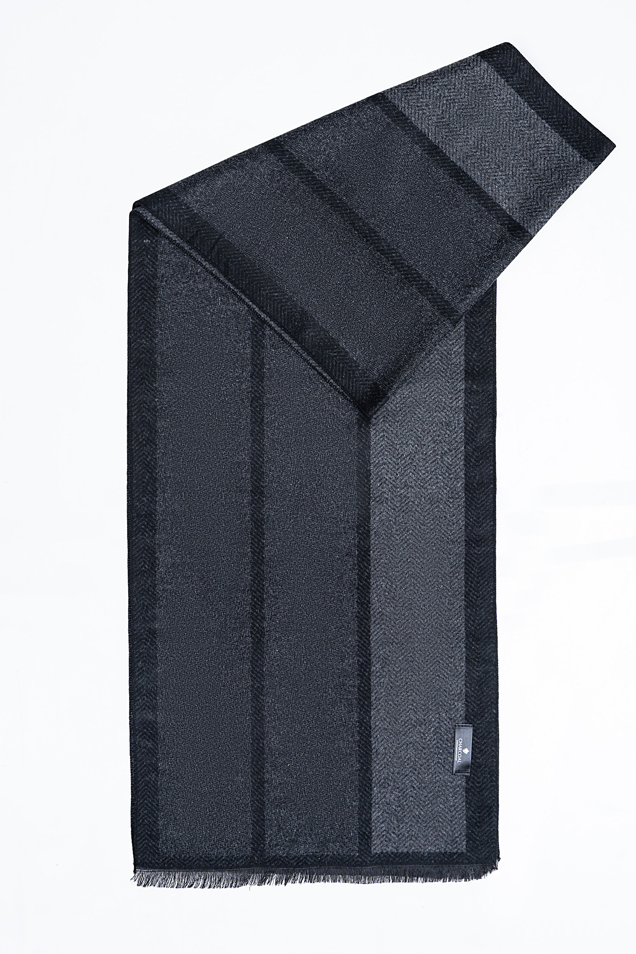 Navy striped scarf draped in a corner with fringed edge and woven label