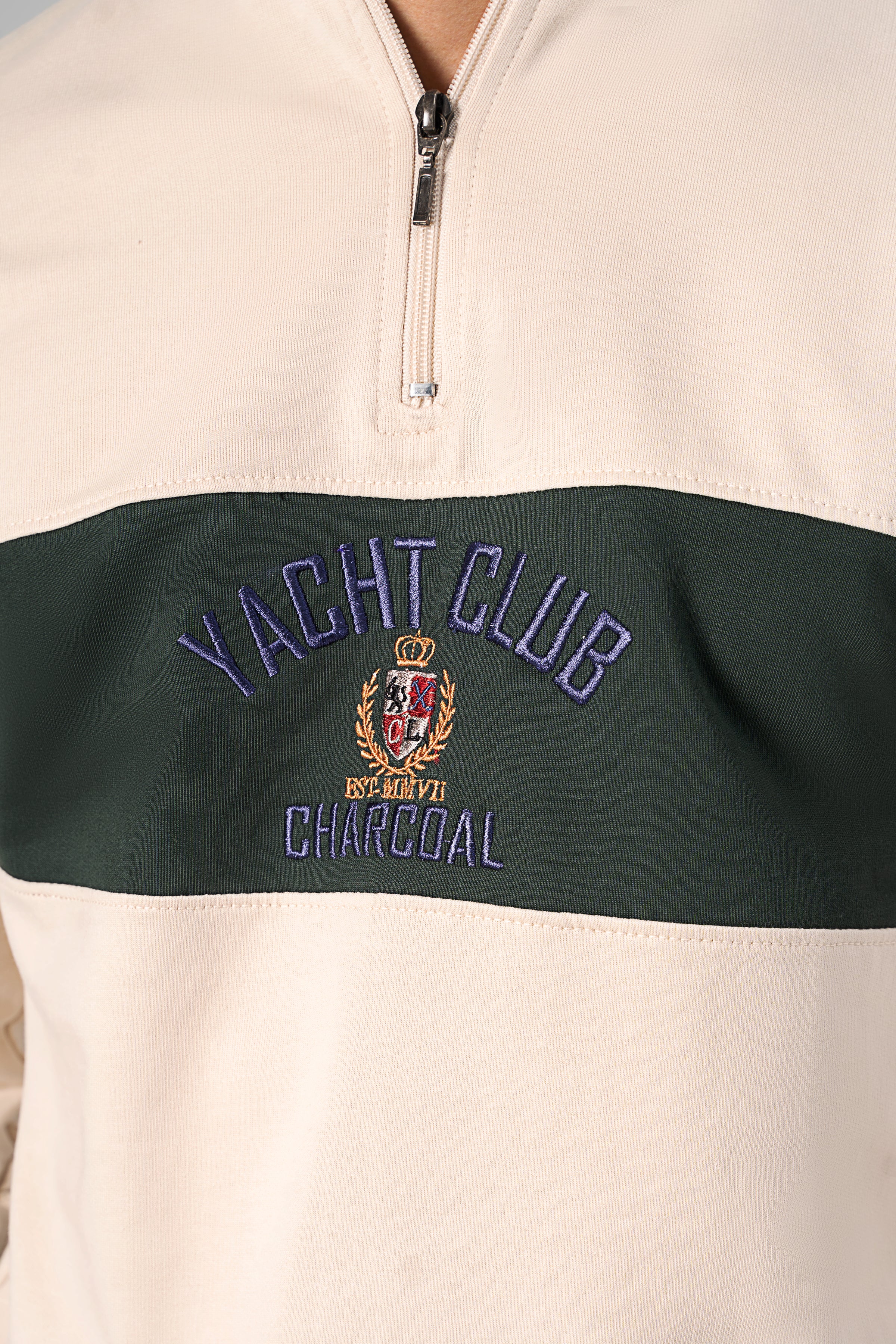 Beige and green mock neck quarter-zip sweatshirt chest graphic patch