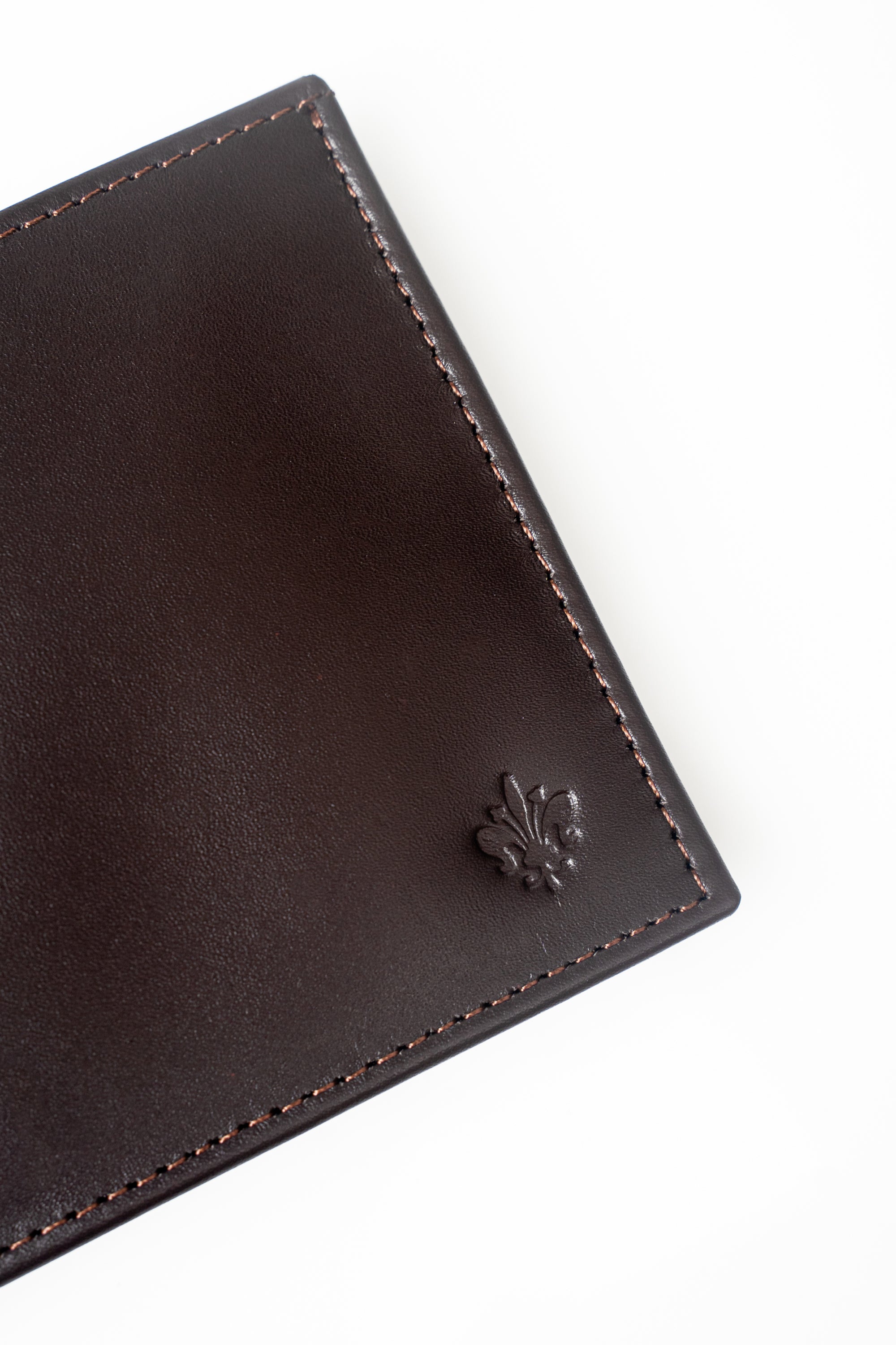 Brown leather wallet front panel with embossed fleur-de-lis logo and stitching