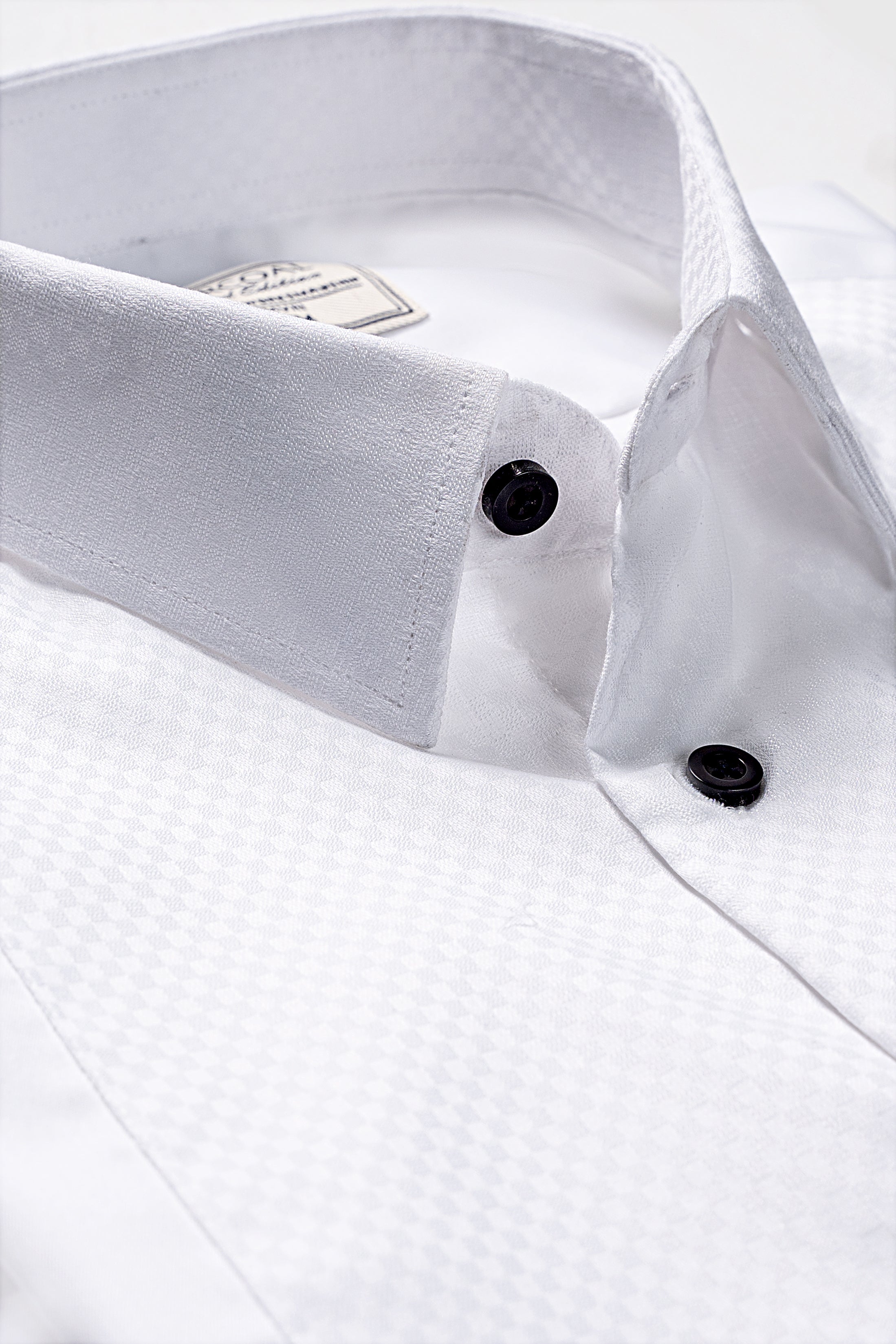 White dress shirt close-up with dark buttons and pointed collar tips