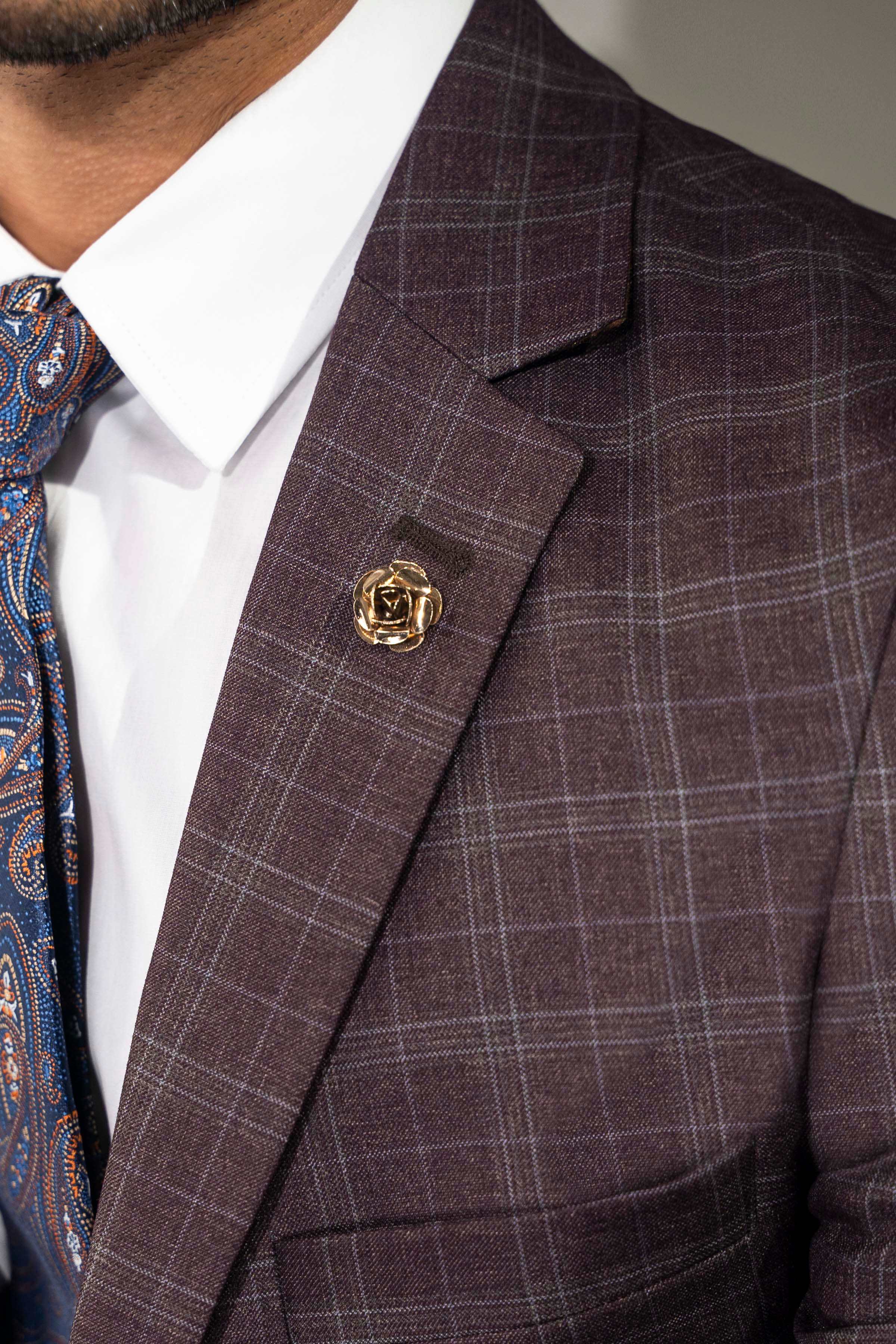 Men's 2-piece suit lapel close-up with gold-tone pin on maroon plaid jacket