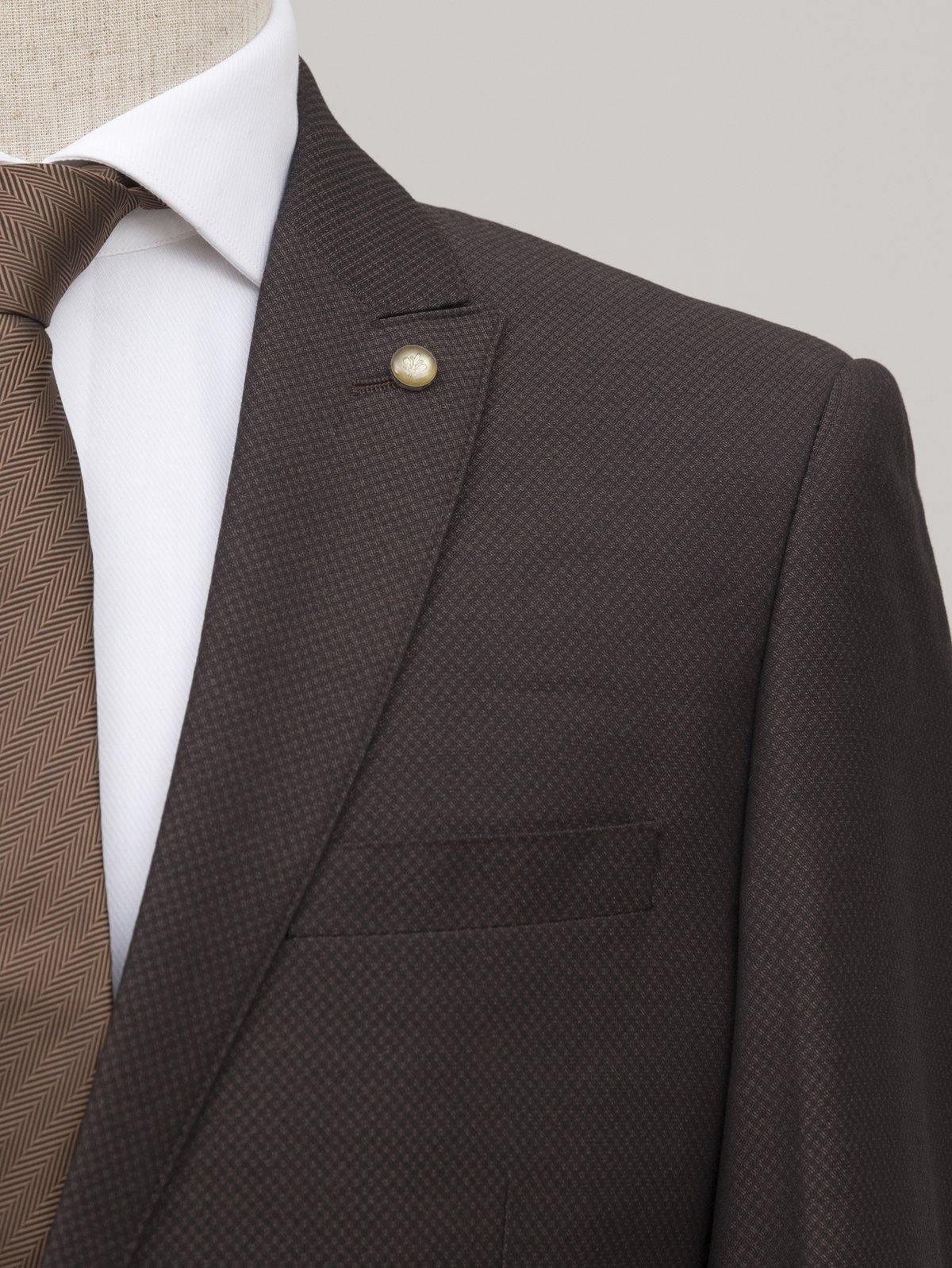 Brown textured suit jacket lapel with gold button and white shirt collar