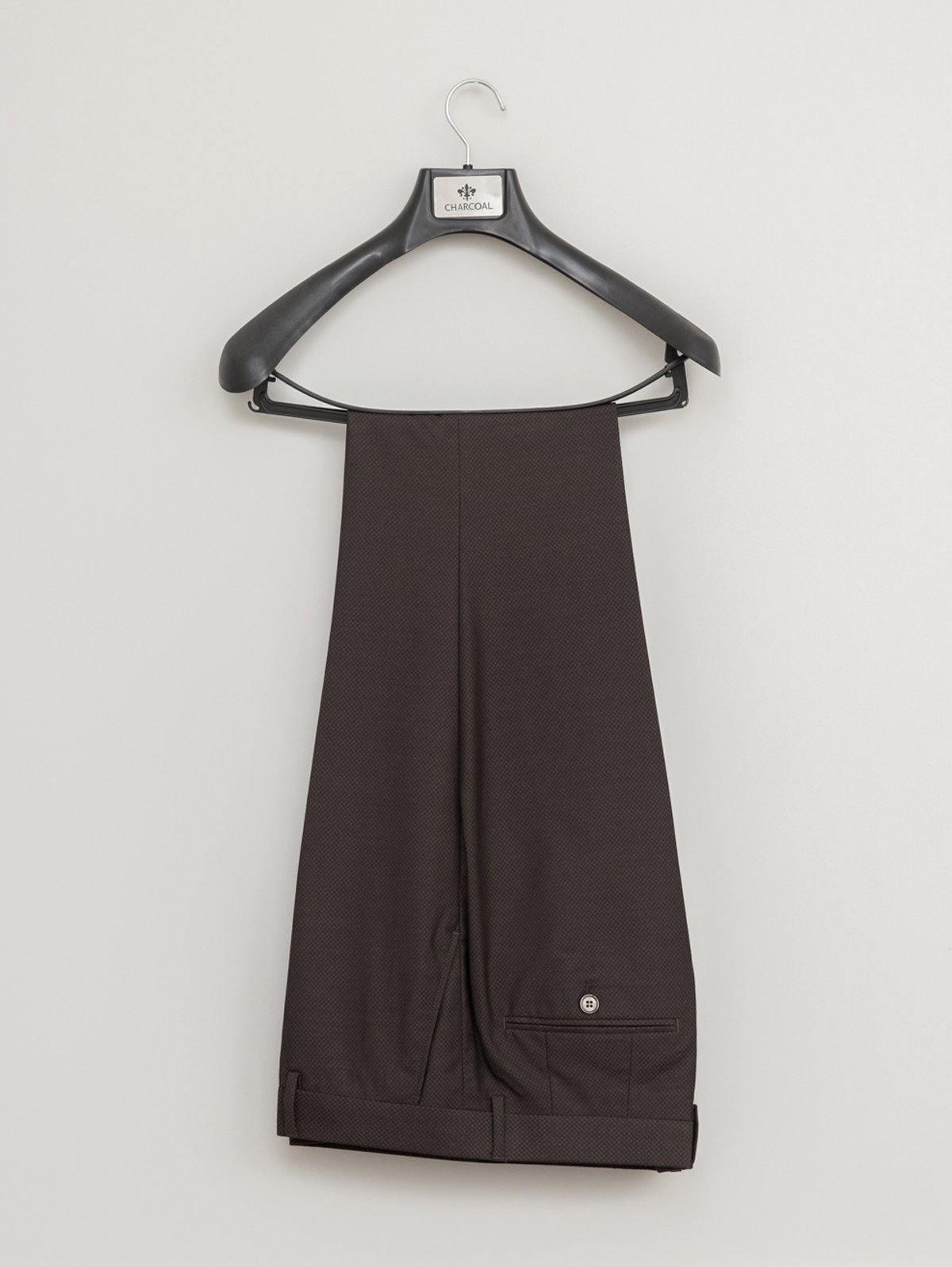 Brown dress pant leg with cuff and side pocket, hanging on black hanger