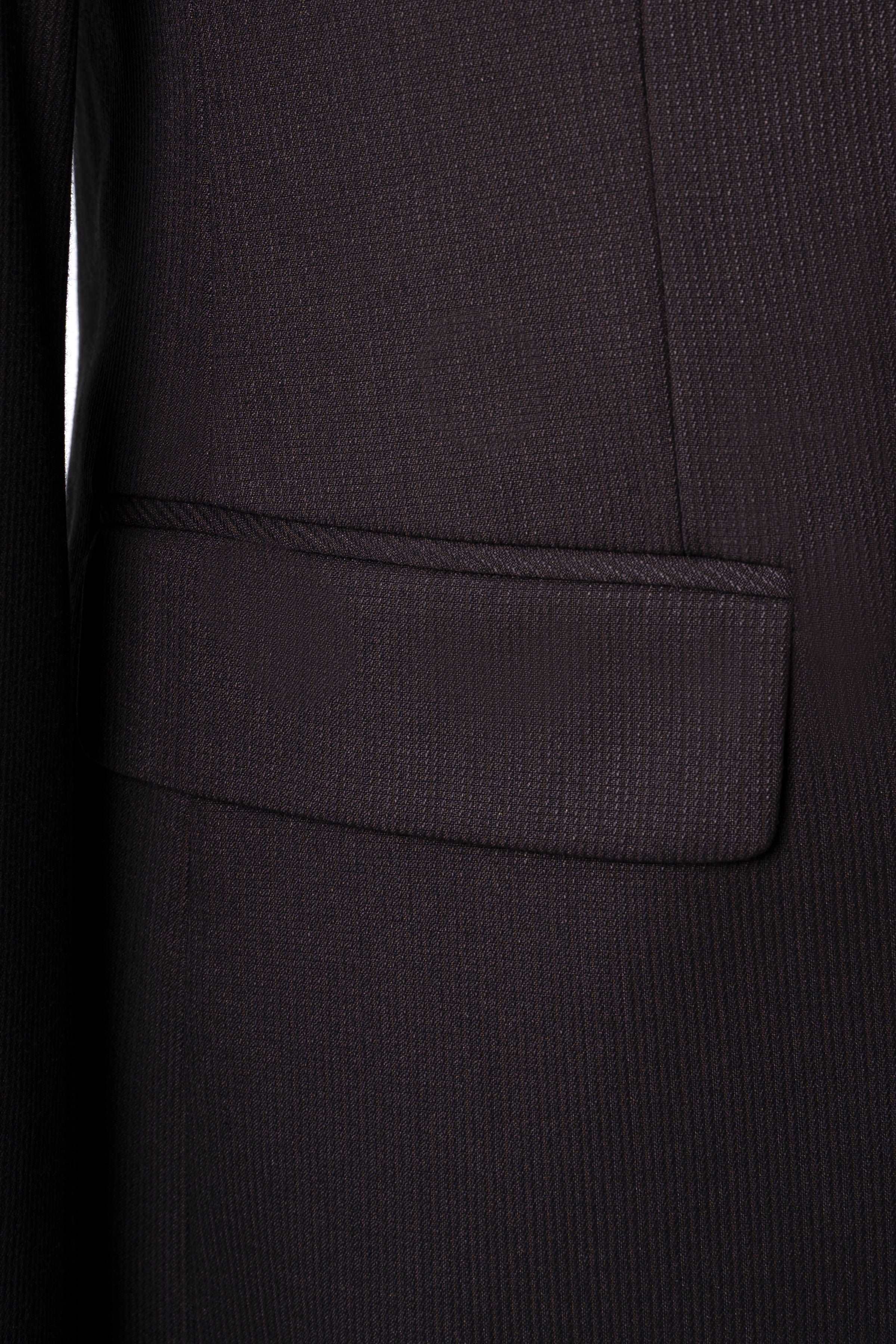 Brown suit jacket front pocket close-up with welt seam and smooth trim