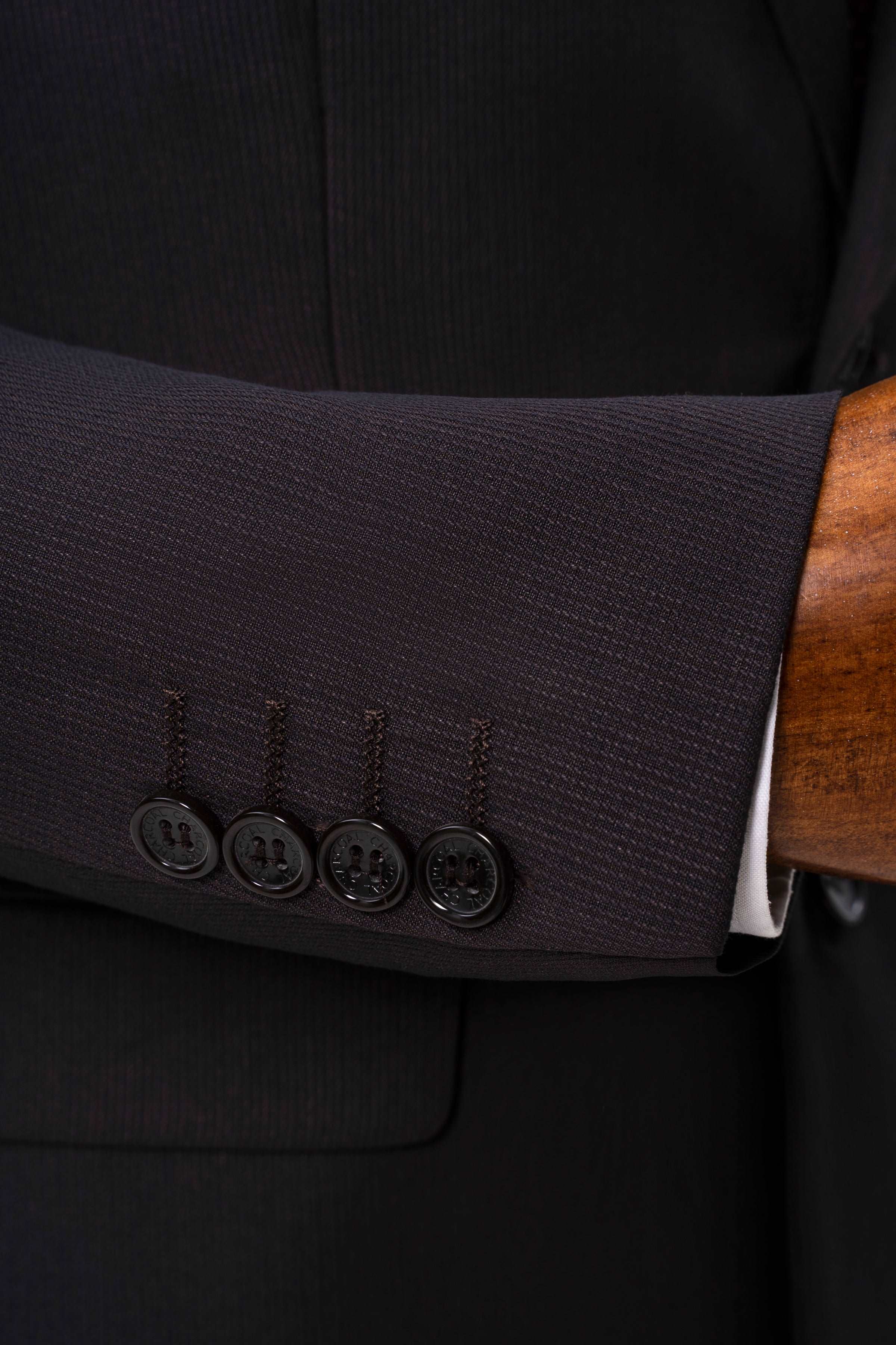 Brown suit jacket cuff close-up with four buttons and dark stitching