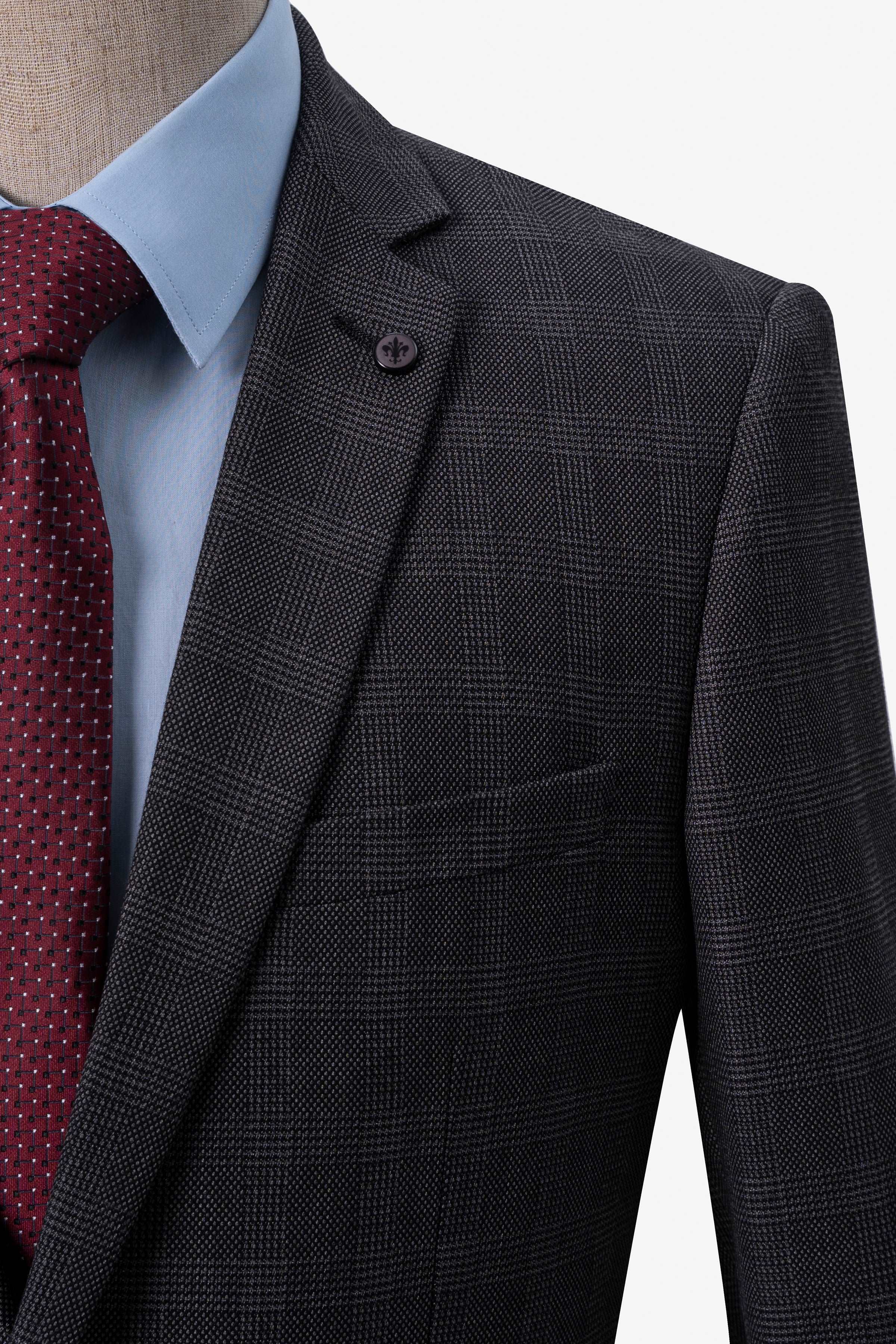 Dark grey plaid suit jacket shoulder and sleeve with burgundy tie visible