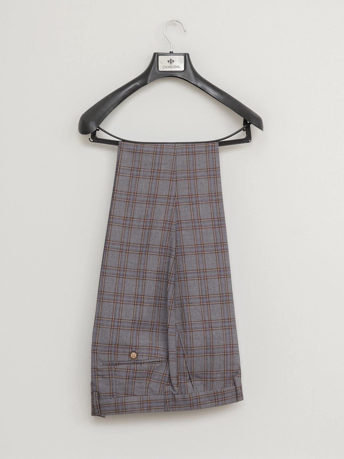 Grey plaid trousers hanging on black hanger