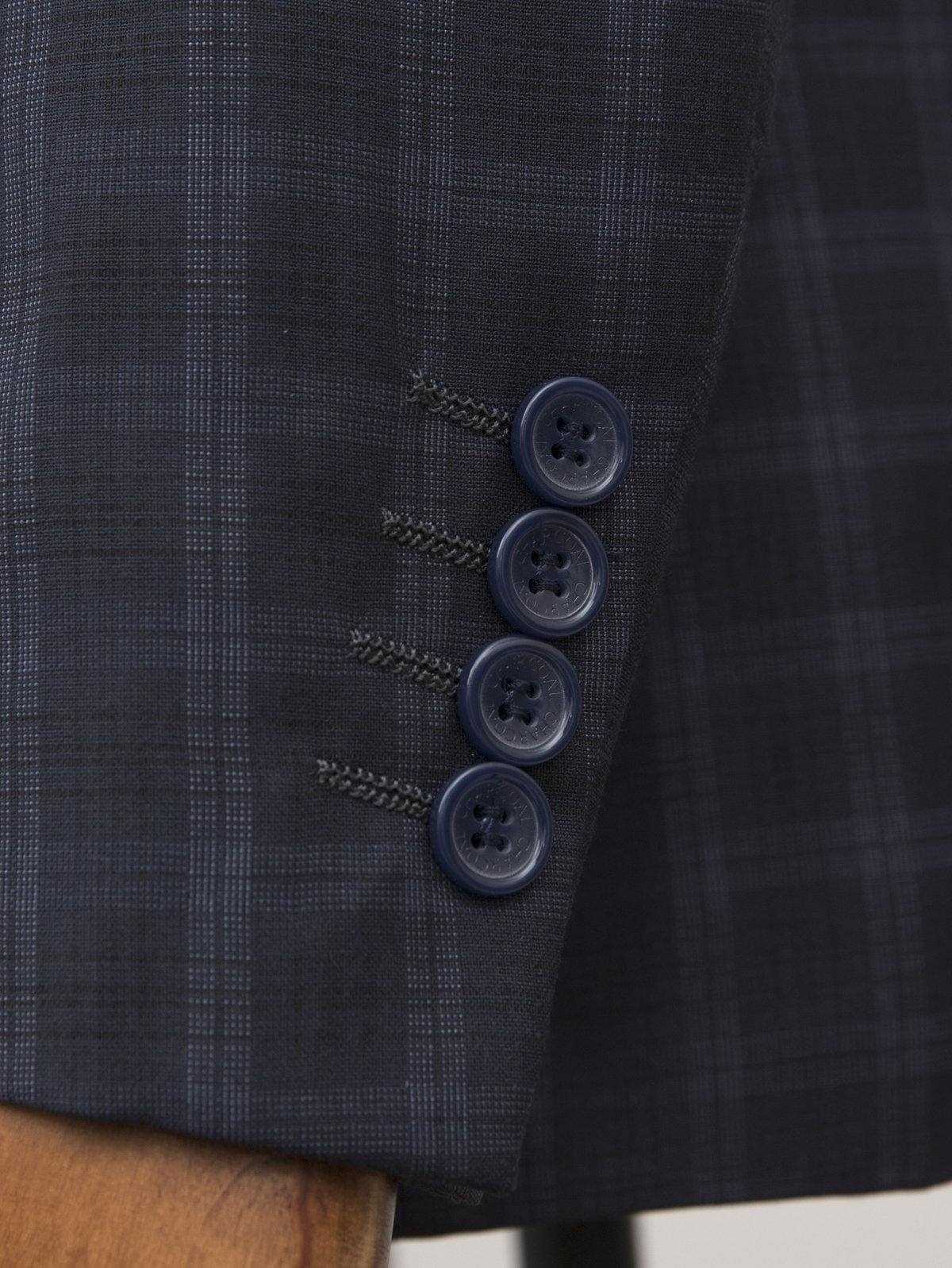 Navy plaid suit jacket front with four dark buttons and tailored seamwork