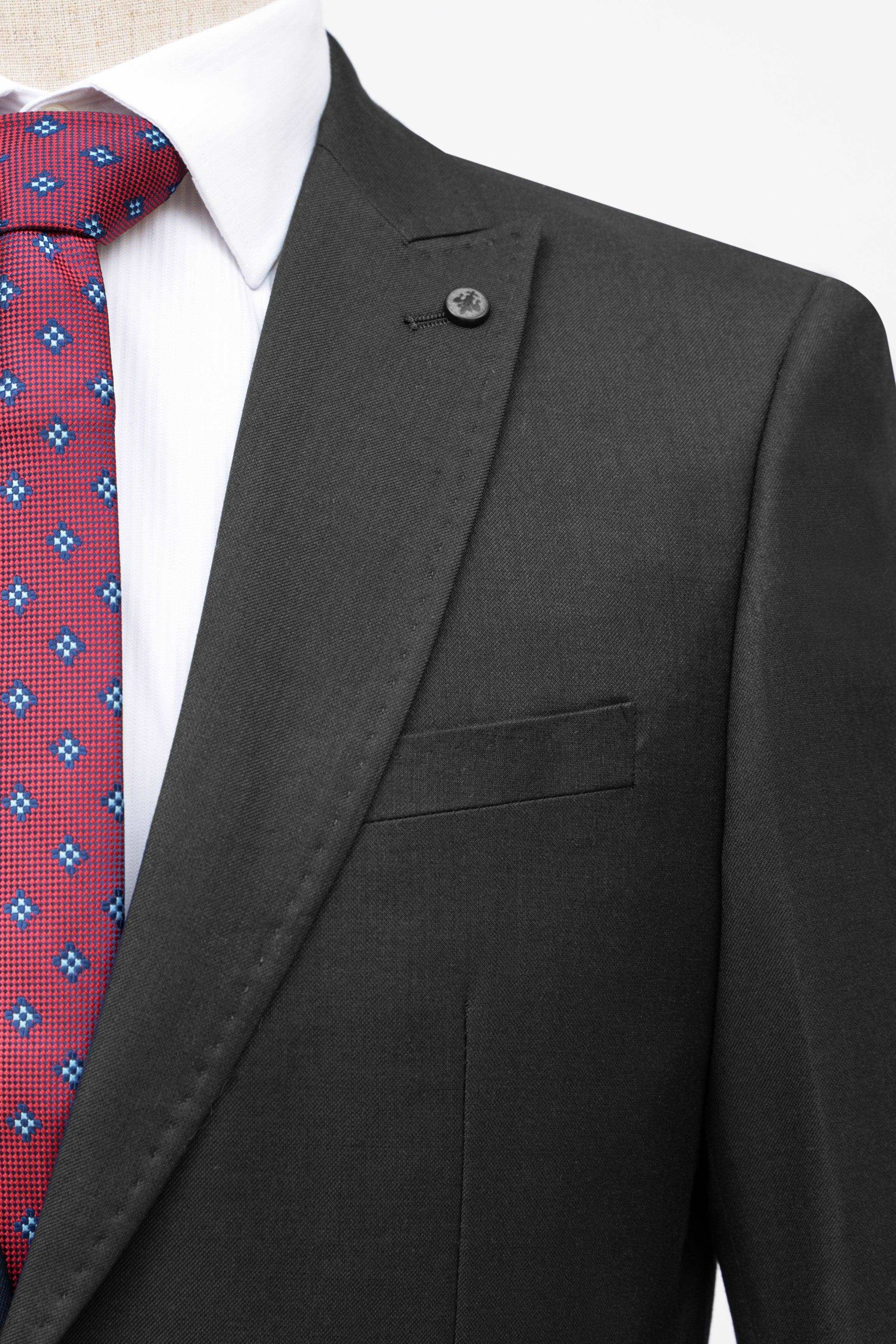 Black slim-fit suit jacket close-up with notch lapel, single button, and chest welt pocket