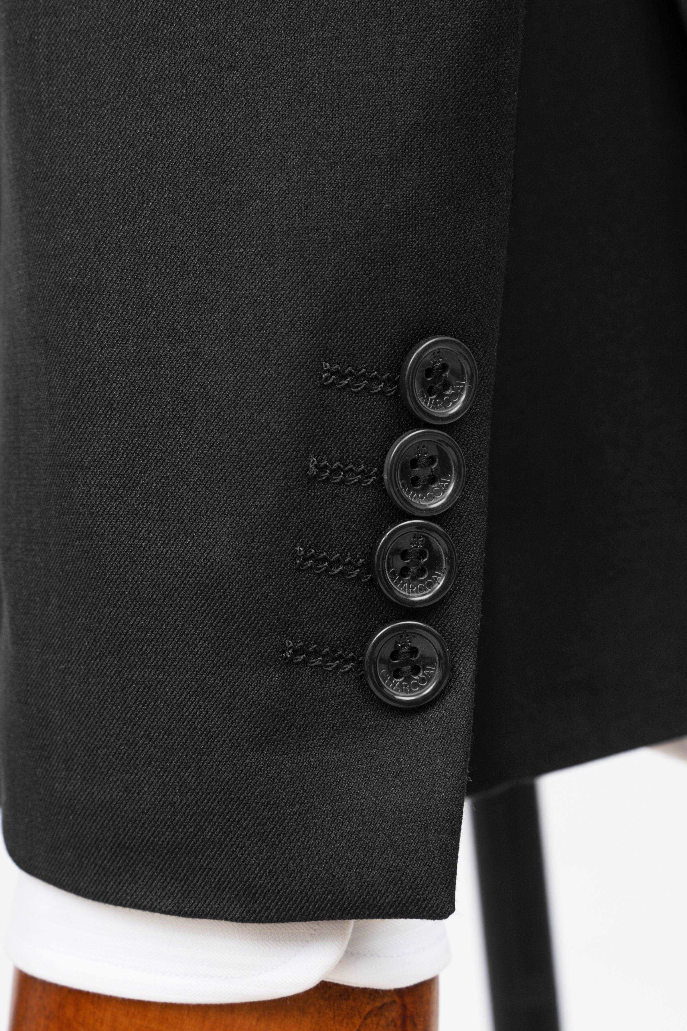 Black suit jacket cuff close-up with four button details and embroidered seam lines