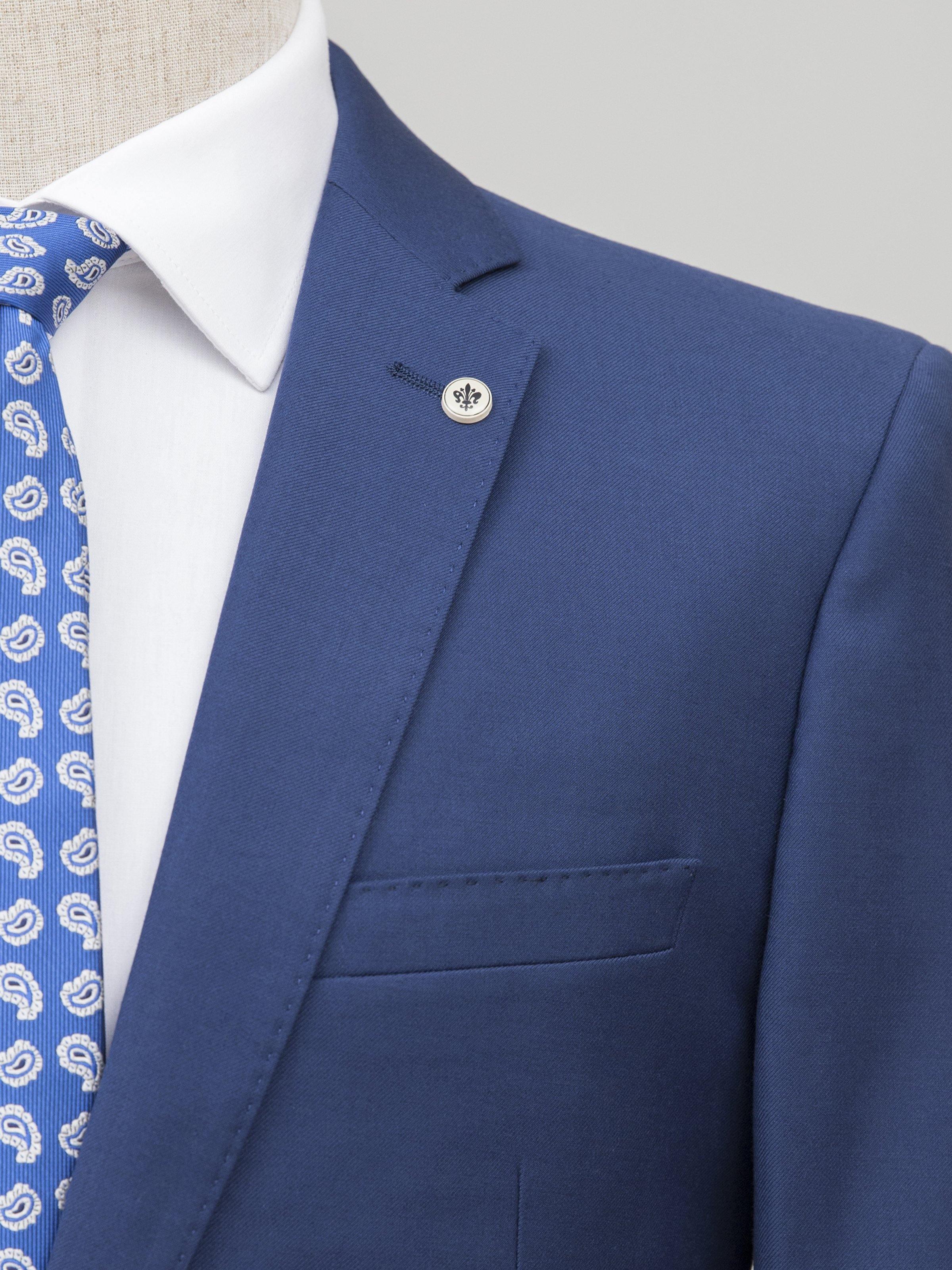 Blue suit blazer lapel and chest pocket detail with decorative button
