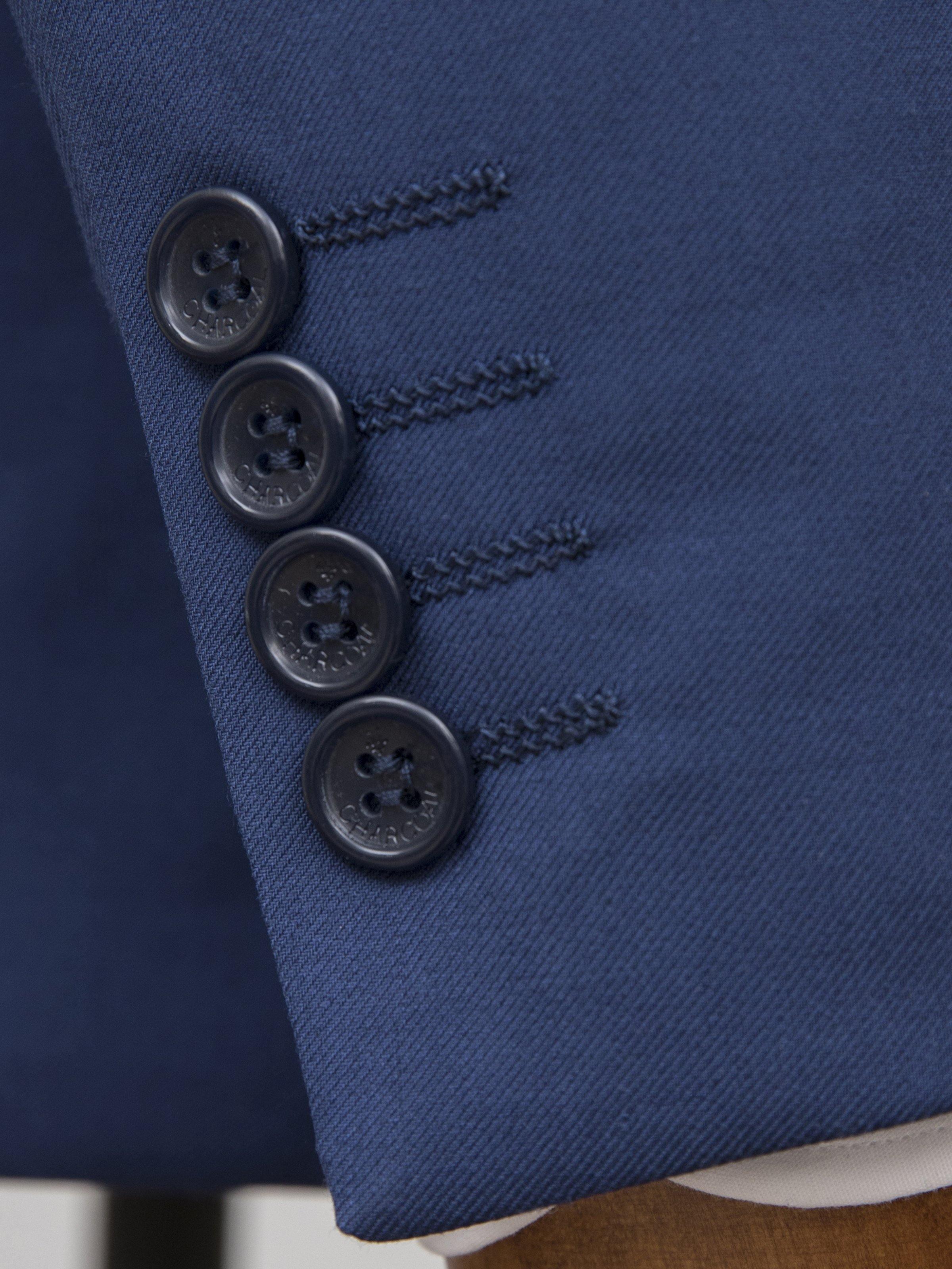 Blue suit cuff with four black buttons and stitched edge detail
