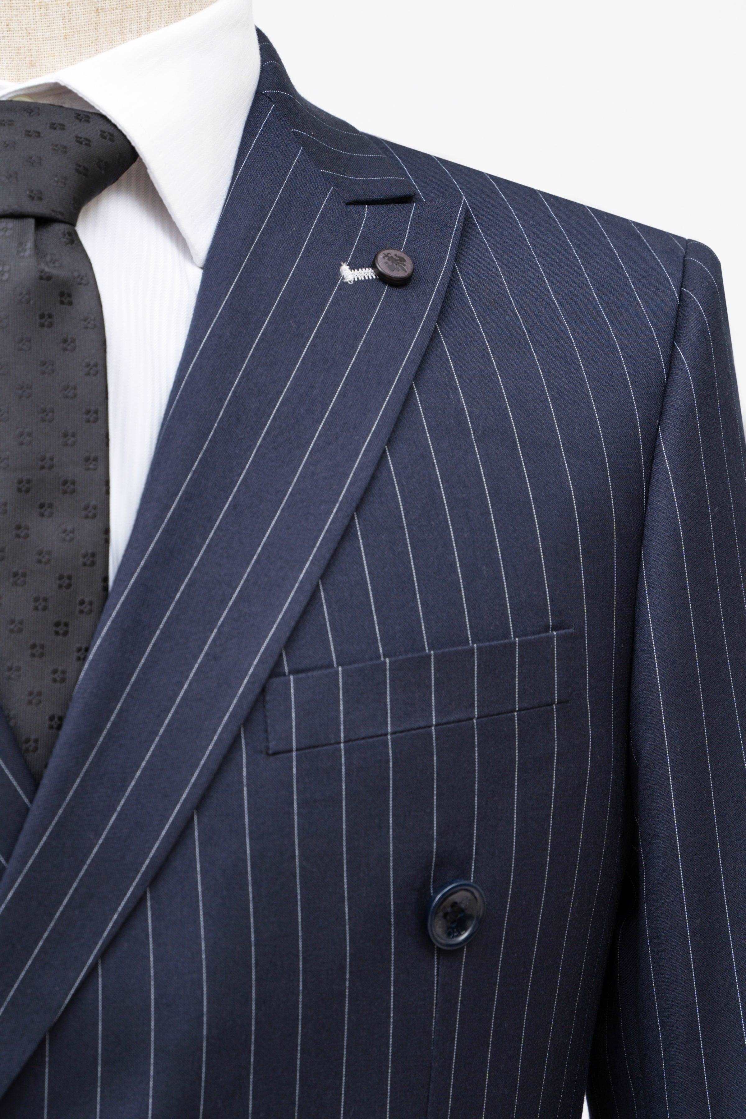 Navy pinstripe double-breasted suit jacket shoulder and lapel with small emblem