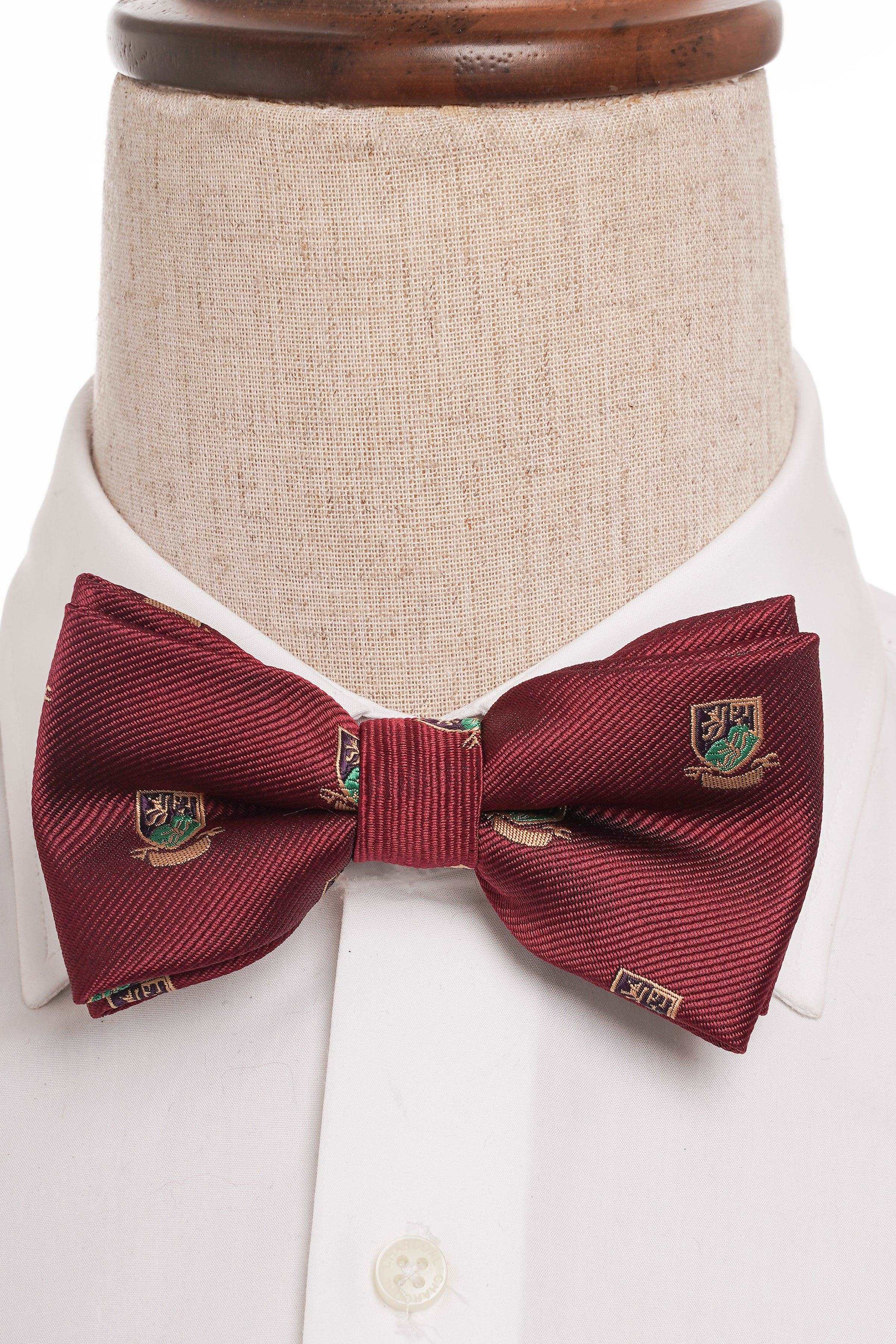 Burgundy striped bow tie with crest patch and center knot on mannequin