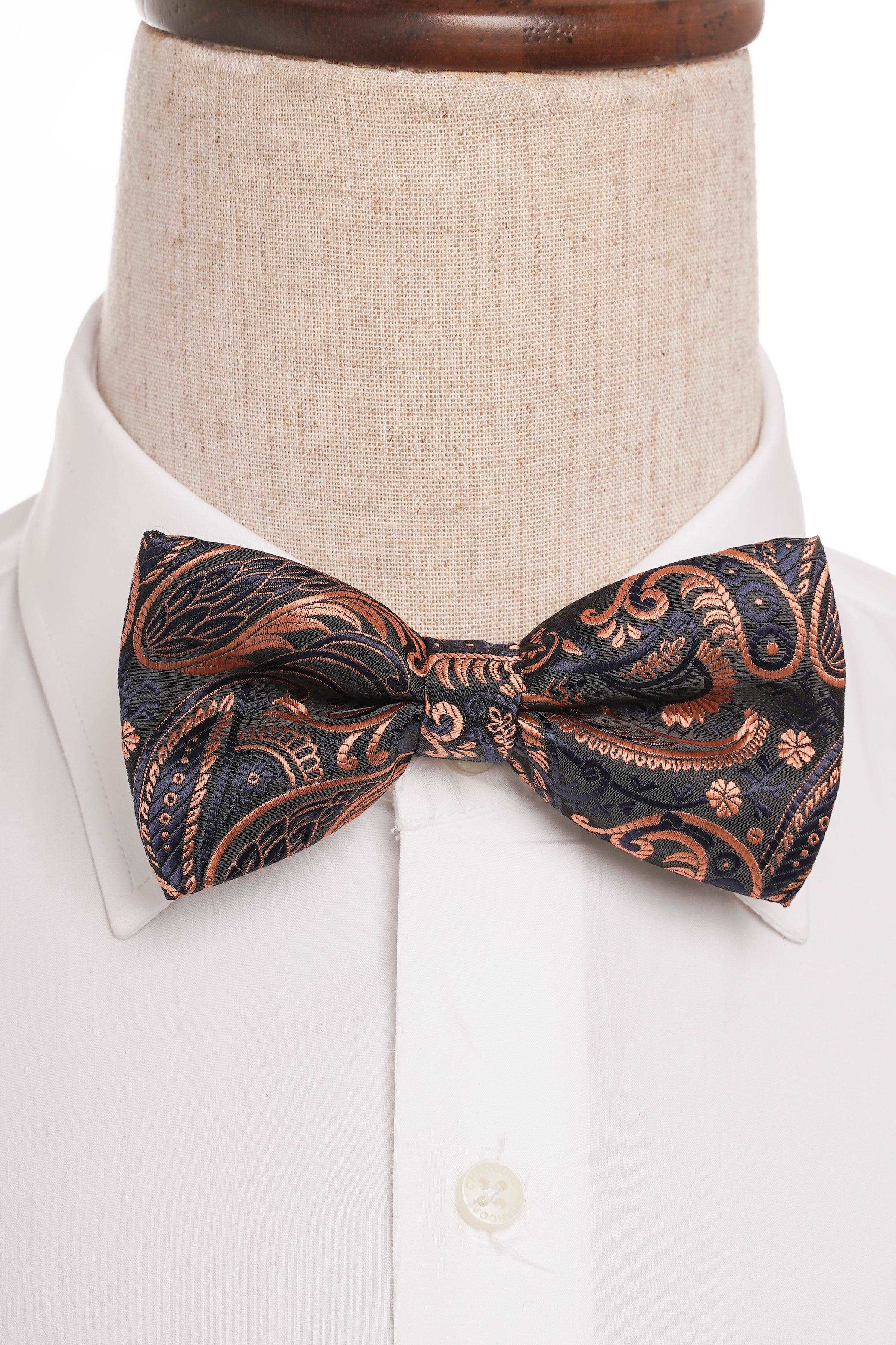 Paisley bow tie worn at the collar, dark blue with rust and gold