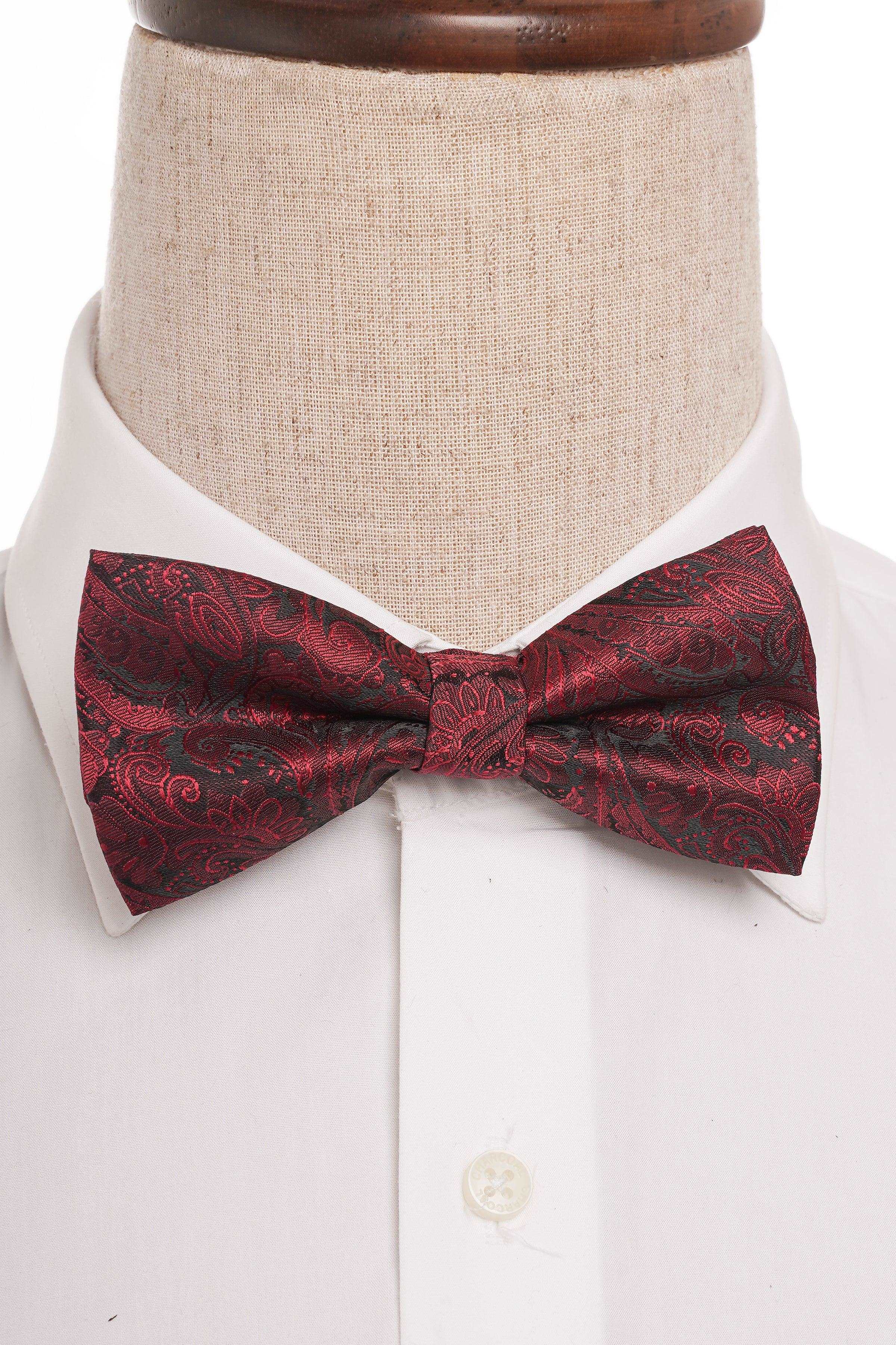 Burgundy patterned bow tie on a white dress shirt, centered under the collar