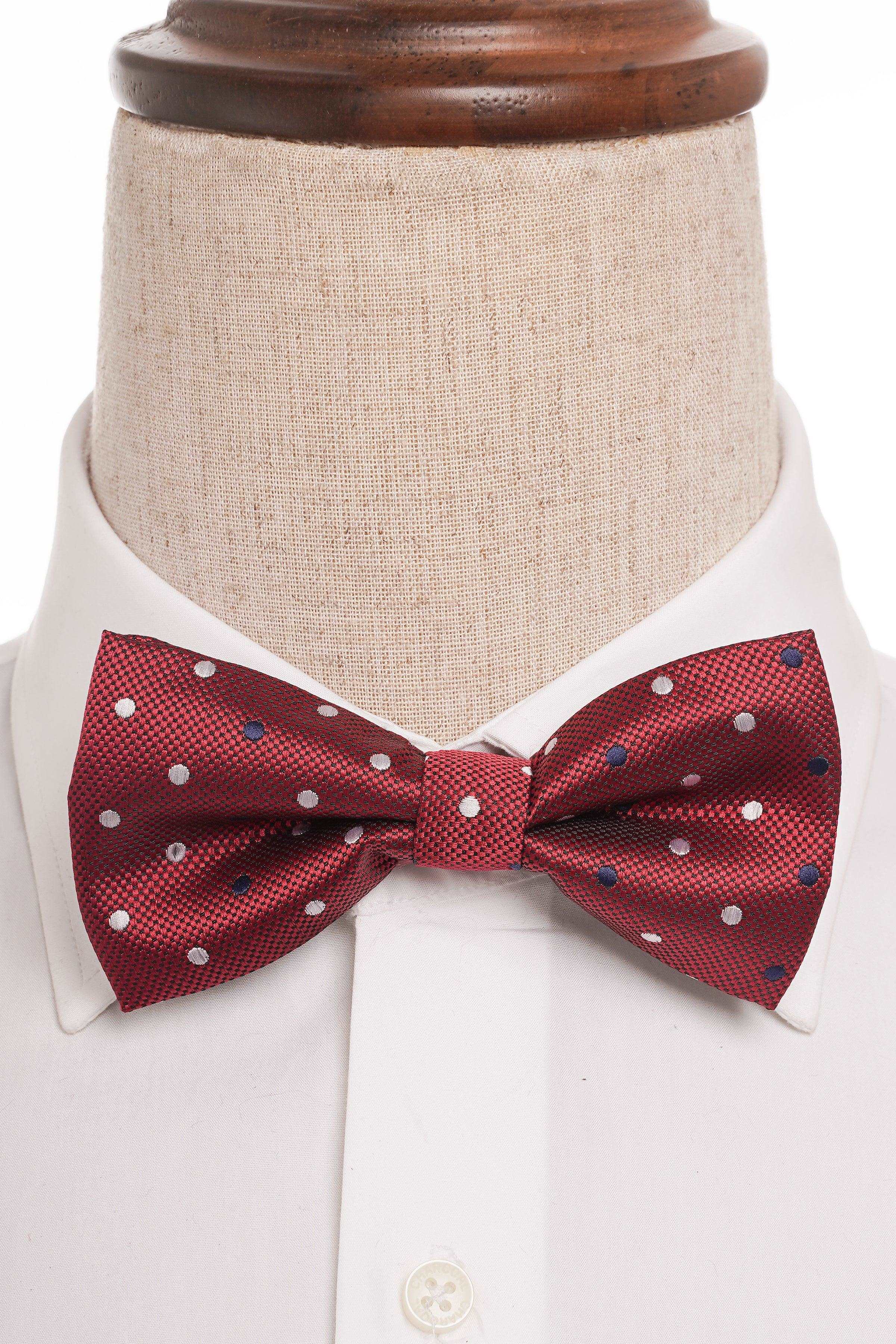 Red bow tie with white polka dots worn at a white shirt collar