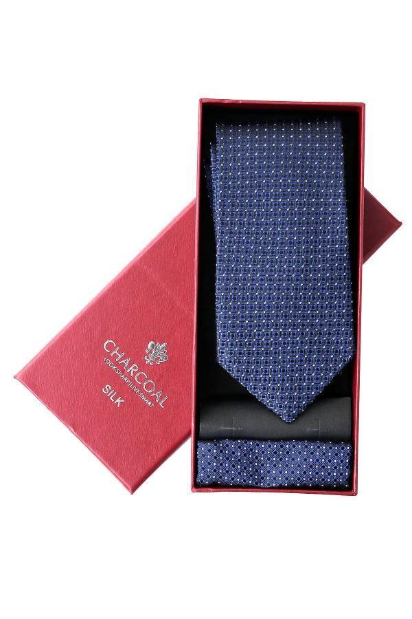 Silk tie set in box with navy patterned tie and red fabric insert