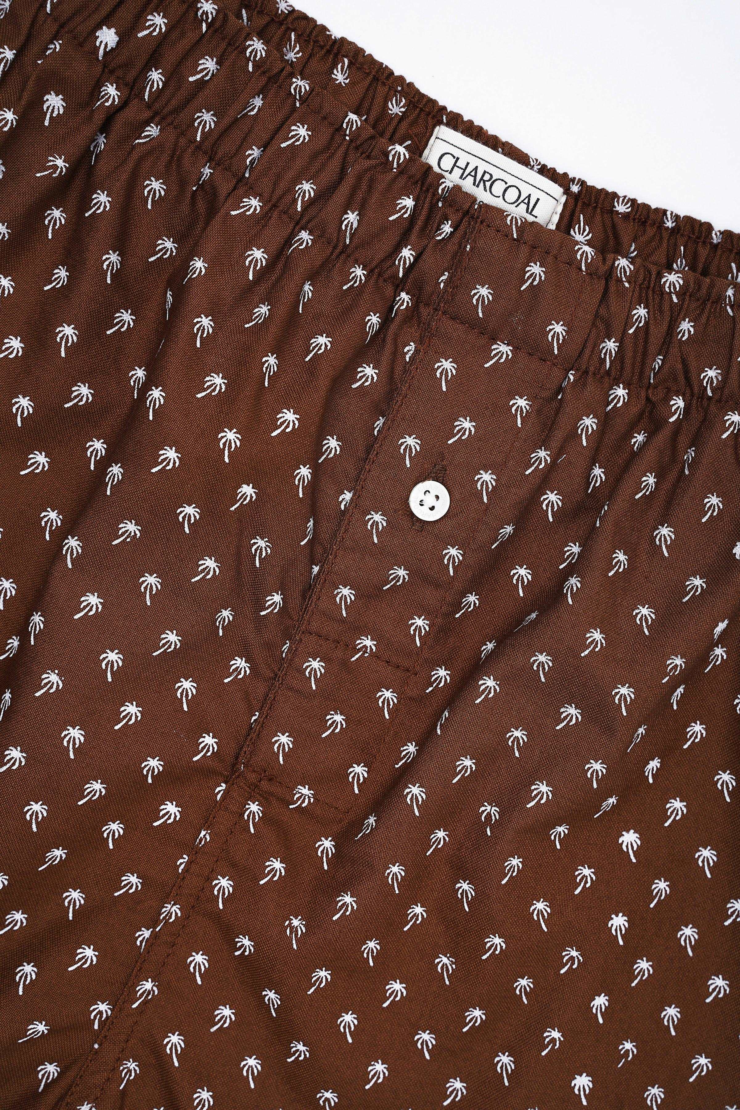 Printed boxer shorts close-up, dark brown with white palm print, button and elastic waist