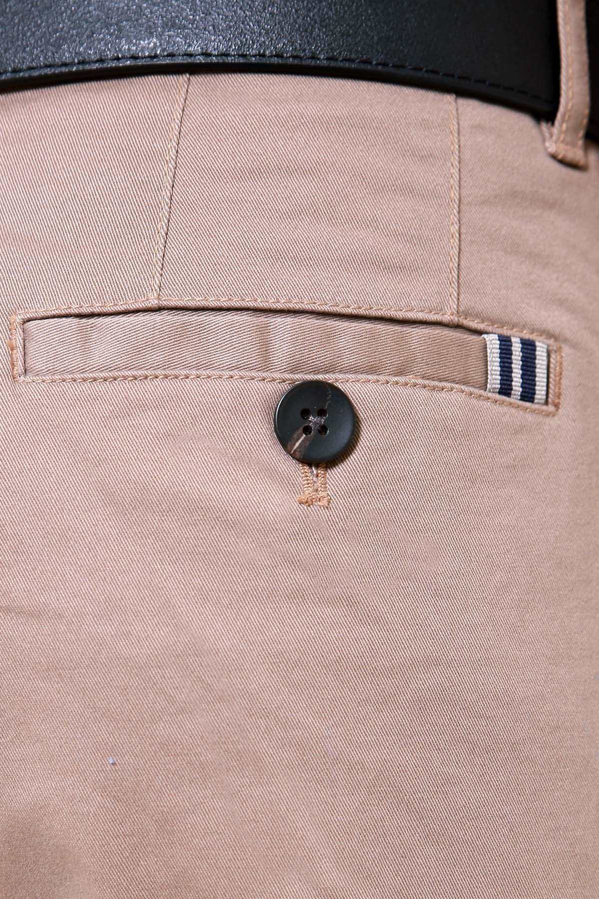 Tan trouser waistband with dark button and striped pocket detail
