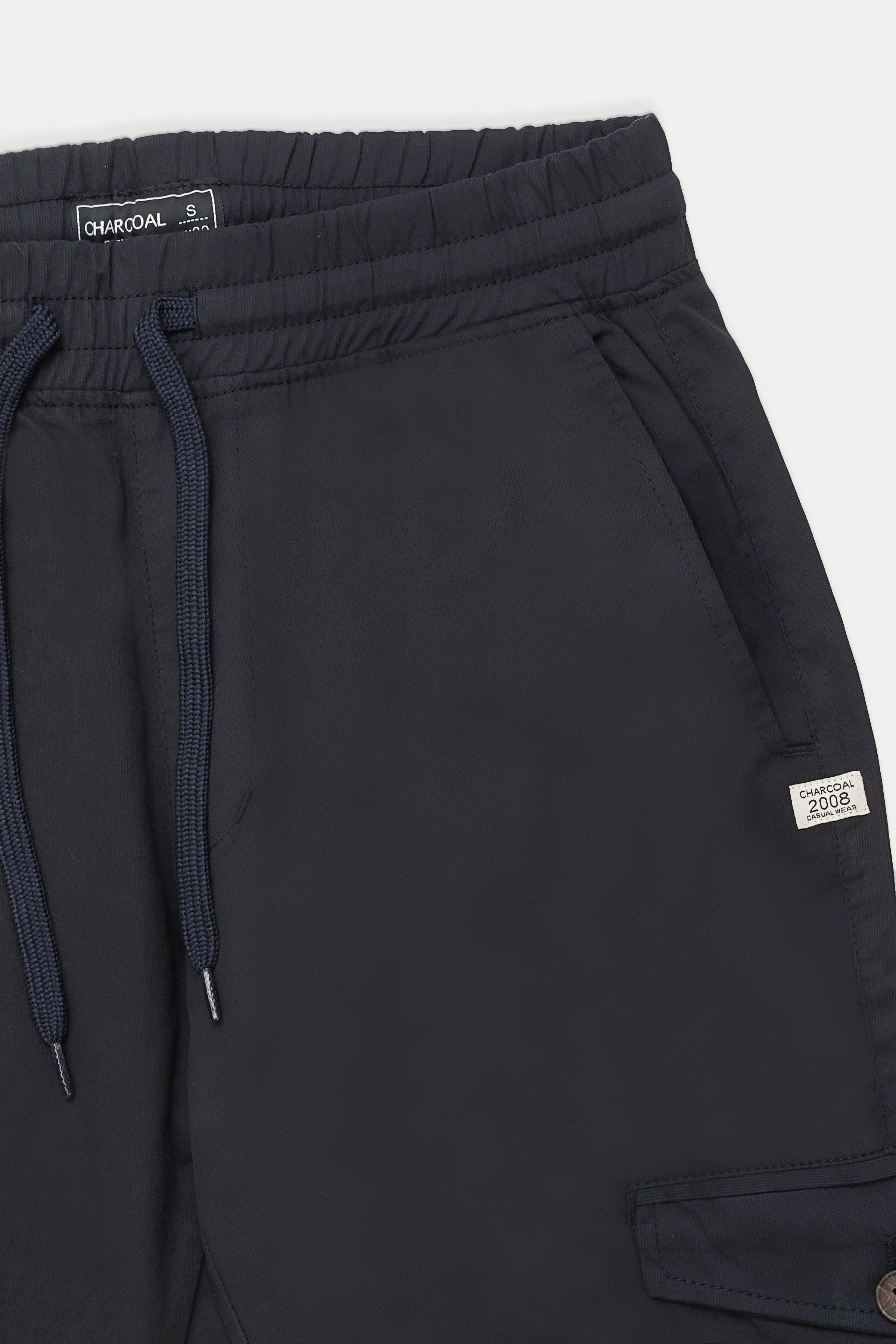 Navy cargo trousers close-up: drawstring waist and patch pocket with label