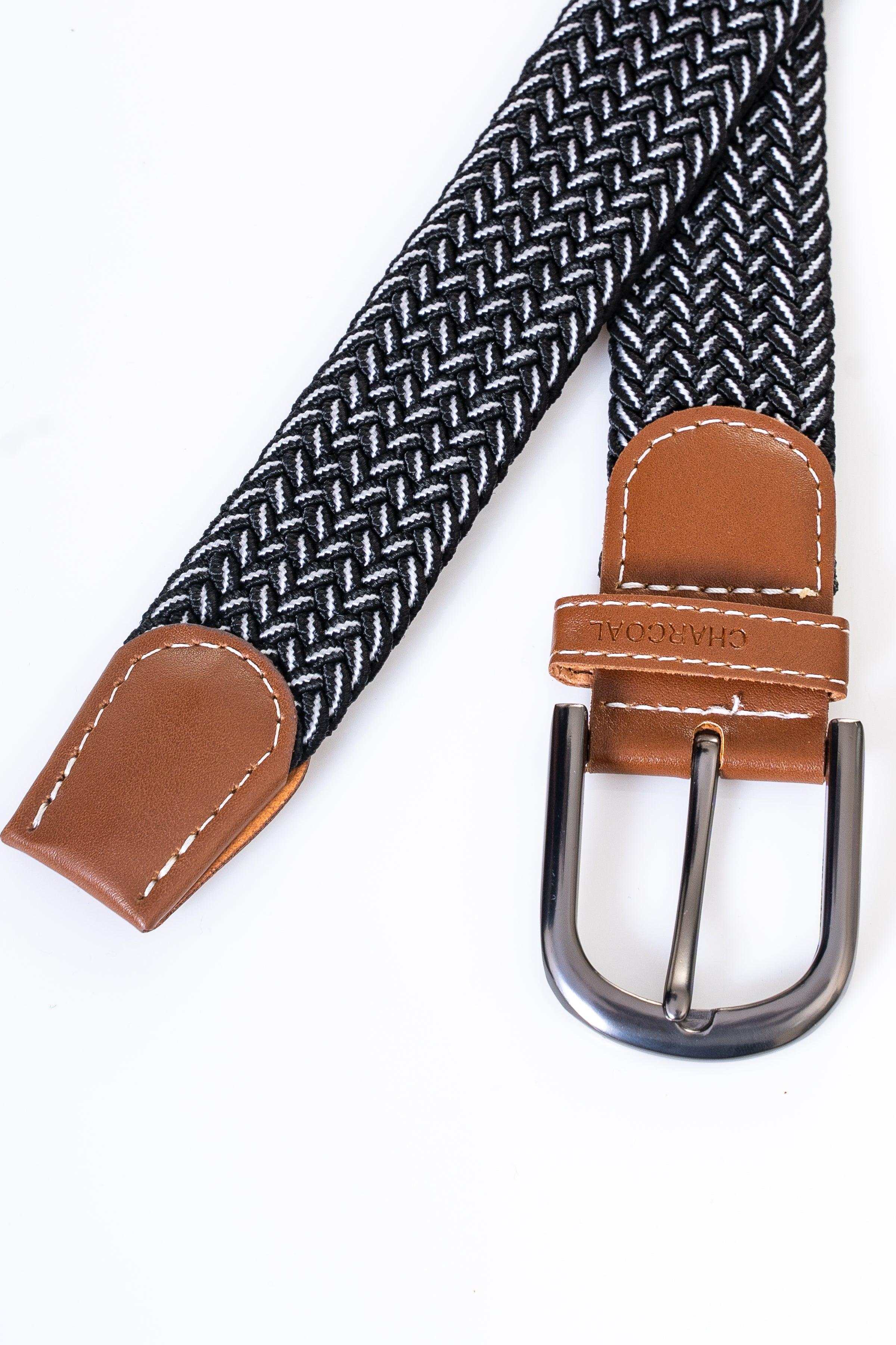 Woven belt with dark zigzag pattern, tan leather ends, and silver buckle.