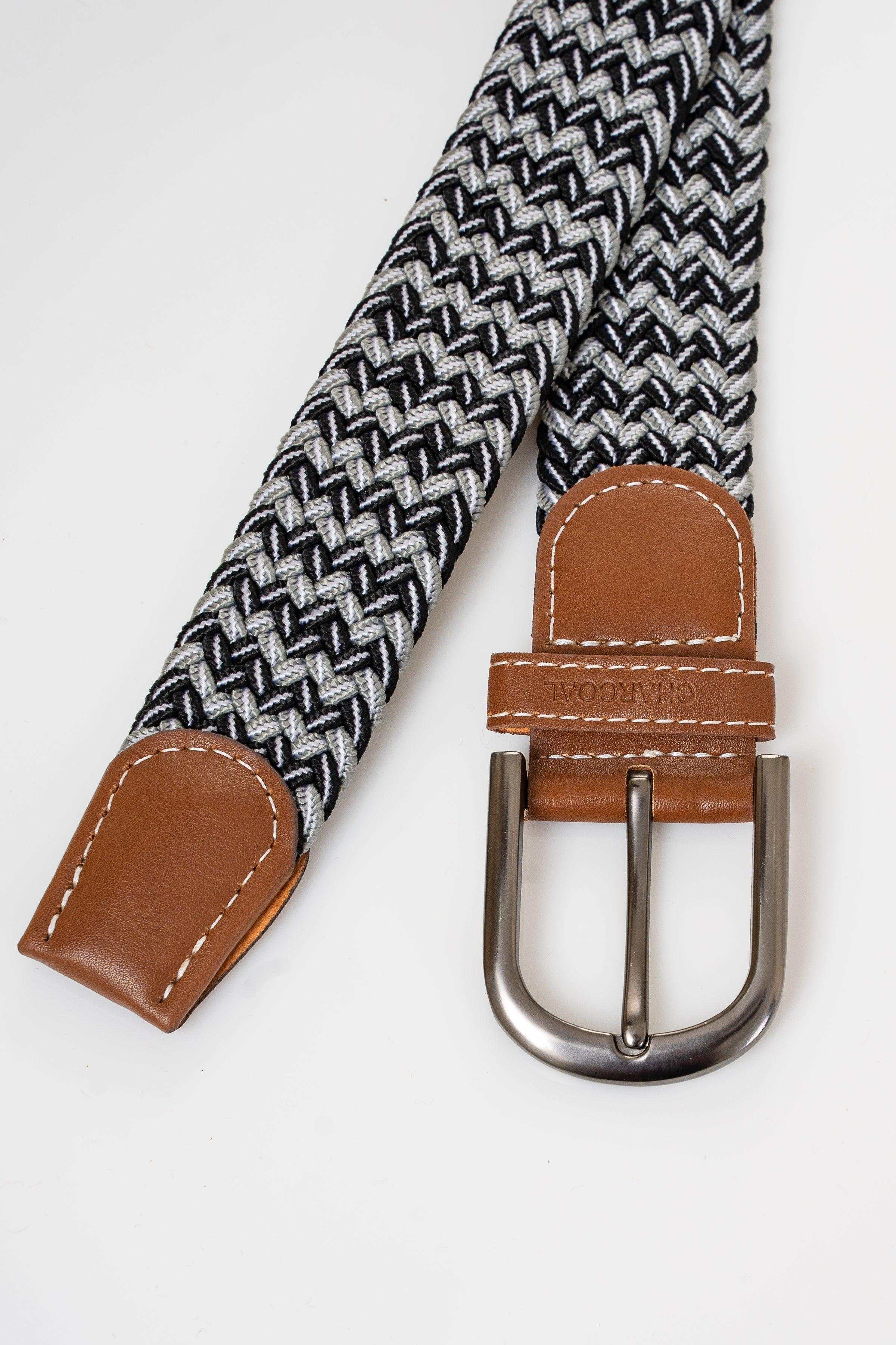 Woven casual belt with brown leather end tabs and metal buckle on black-and-white weave