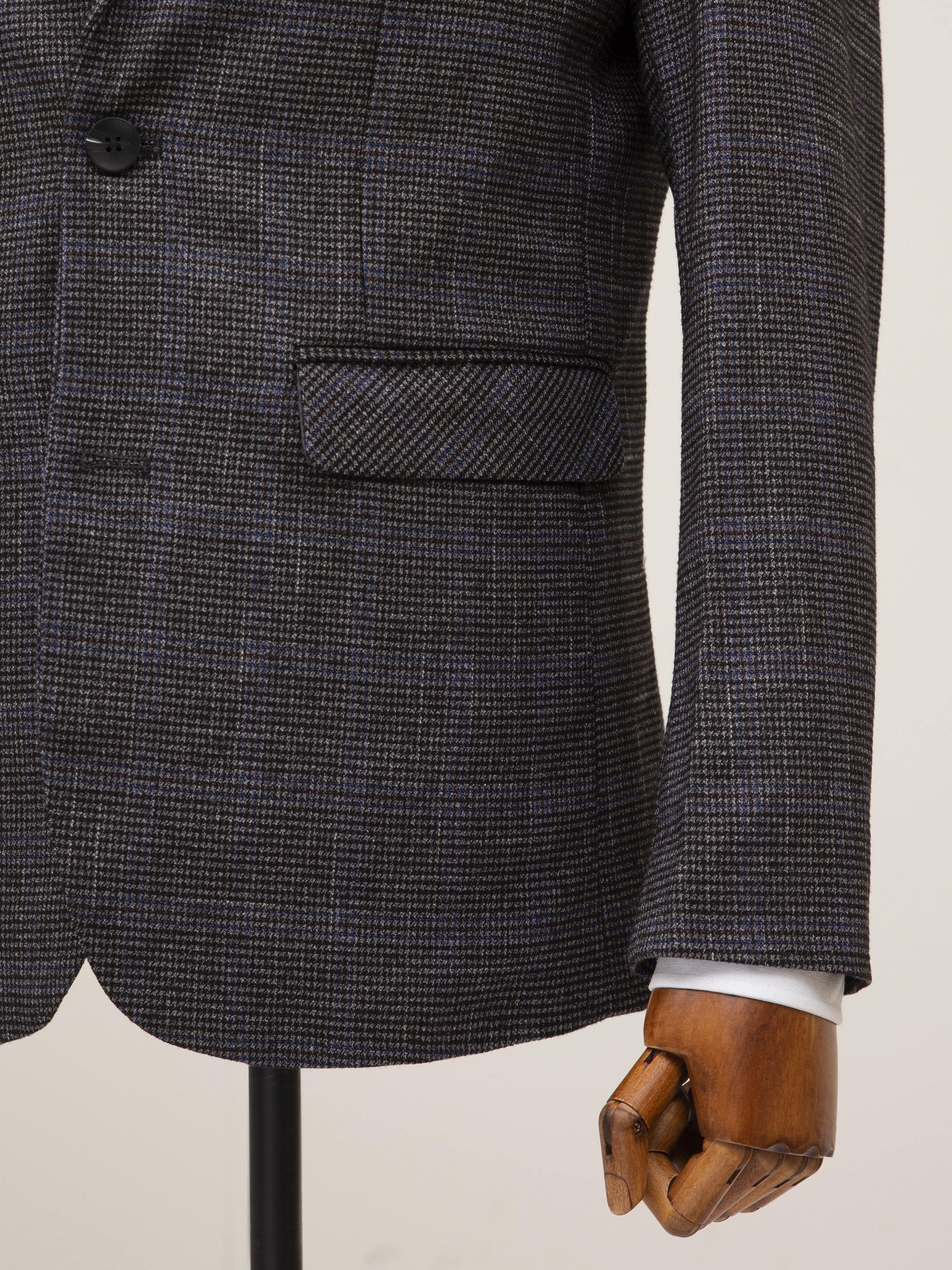 Grey coat with flap pocket detail and textured fabric weave close-up