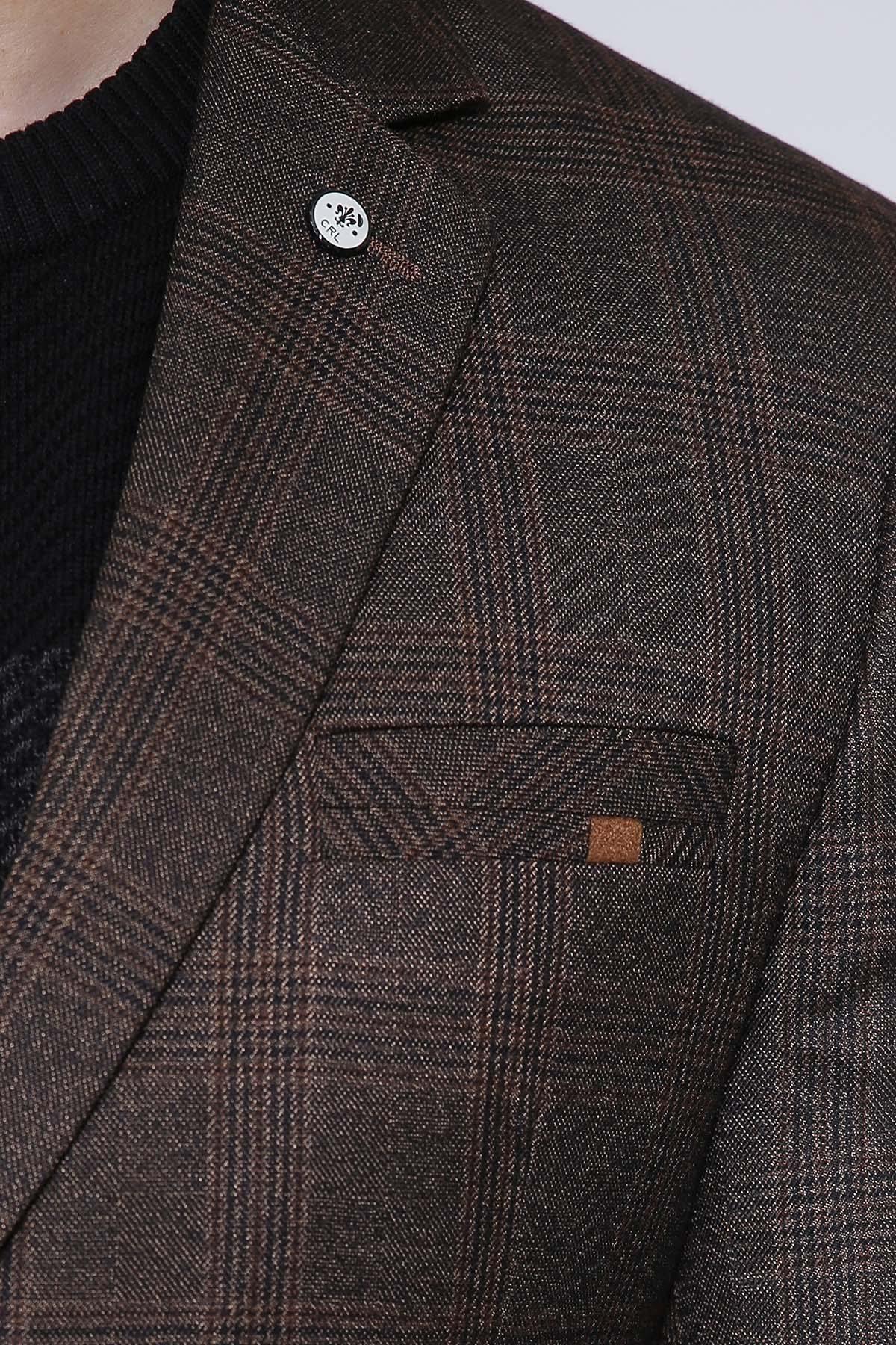Brown plaid coat lapel with round logo button and welt pocket detail